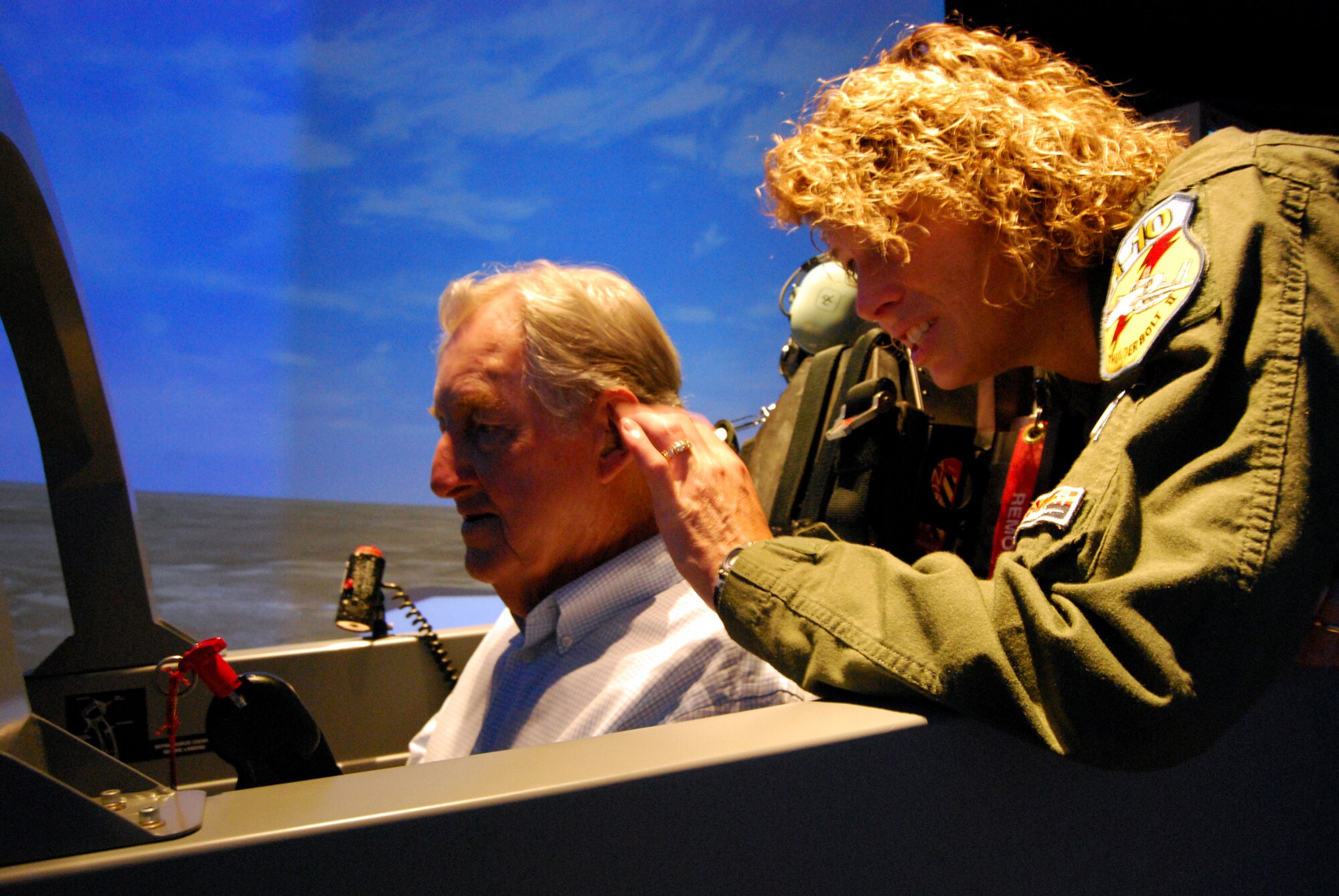 Retired Air Force Lt. Col. Bill Peel, seated, takes a spin in the T-6A Texan II flight simulator May 23 during a visit to Sheppard Air Force Base. Mr. Peel, a veteran of World War II and the Korean and Vietnam wars, said Memorial Day is always a special, yet hard time each year because of all the friends who didn't come home from each war, and those who've passed on since. Also pictured is 80th Flying Training Wing Director of Staff Lt. Col. Jill Long. (U.S. Air Force photo/John Ingle)