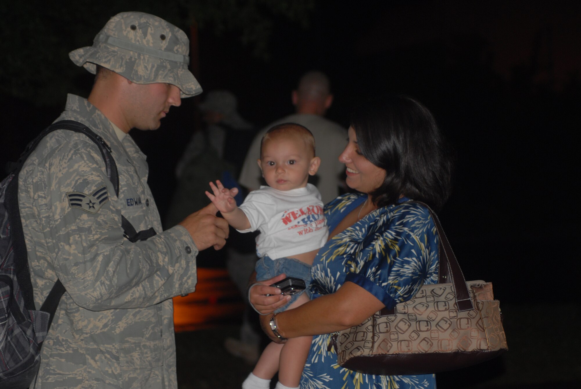 Senior Airman John Edwards, 3rd Aerial Port Squadron, gets reacquainted with his wife Hayley and son Luke, 8 months, after returning home May 15. A total of 19 Airmen returned following their deployment to Al Asad Air Base, Iraq. (U.S. Air Force Photo by Airman 1st Class Mindy Bloem)