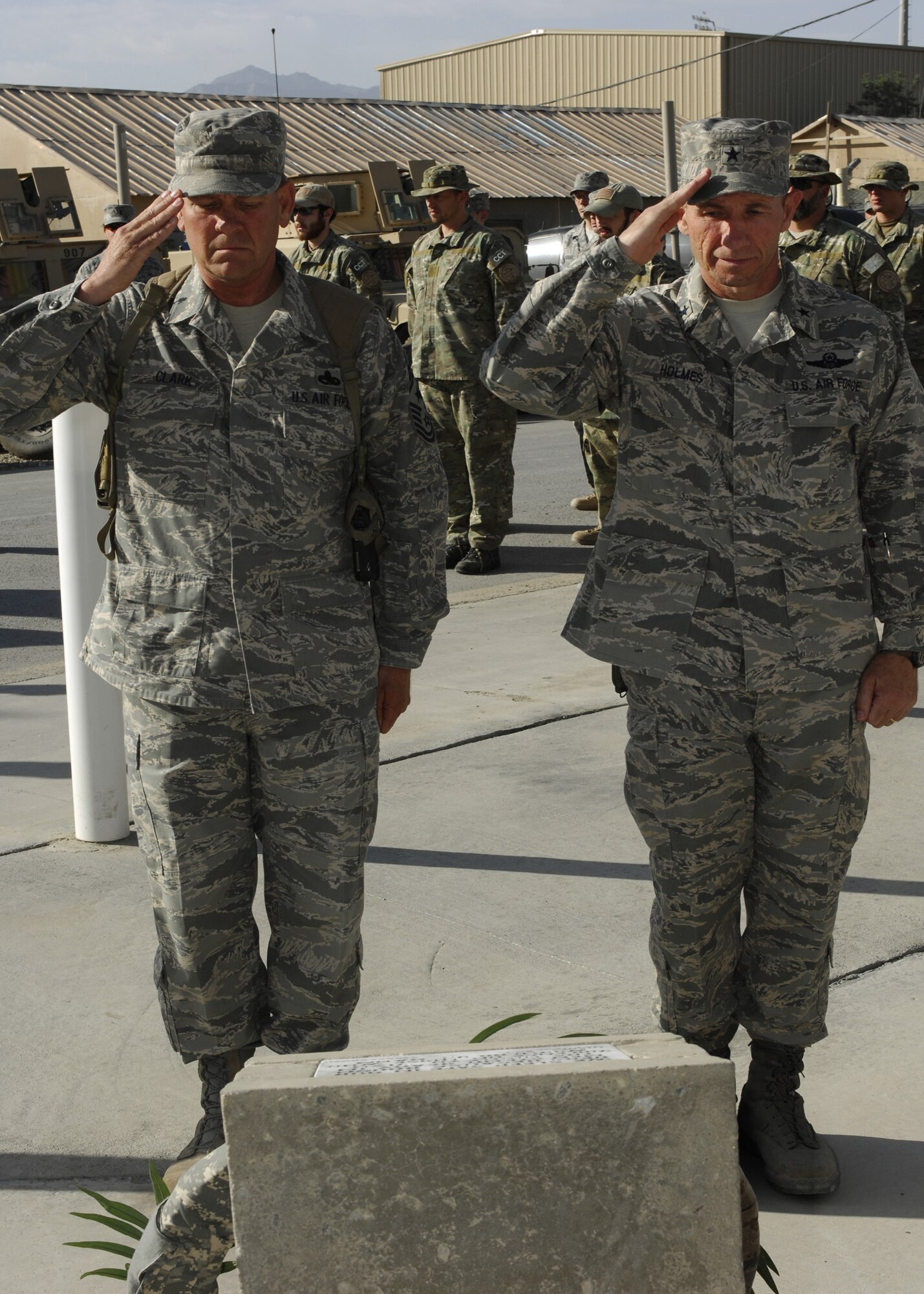 BAGRAM AIR FIELD, Afghanistan – Brig. Gen. Mike Holmes, 455th Air Expeditionary Wing commander and 455 AEW Command Chief Master Sgt. Ray Clark pay tribute to those who have given the ultimate sacrifice by saluting the wreath laid in their honor during the wing’s memorial ceremony here May 26. (U.S. Air Force photo by Capt. Toni Tones)