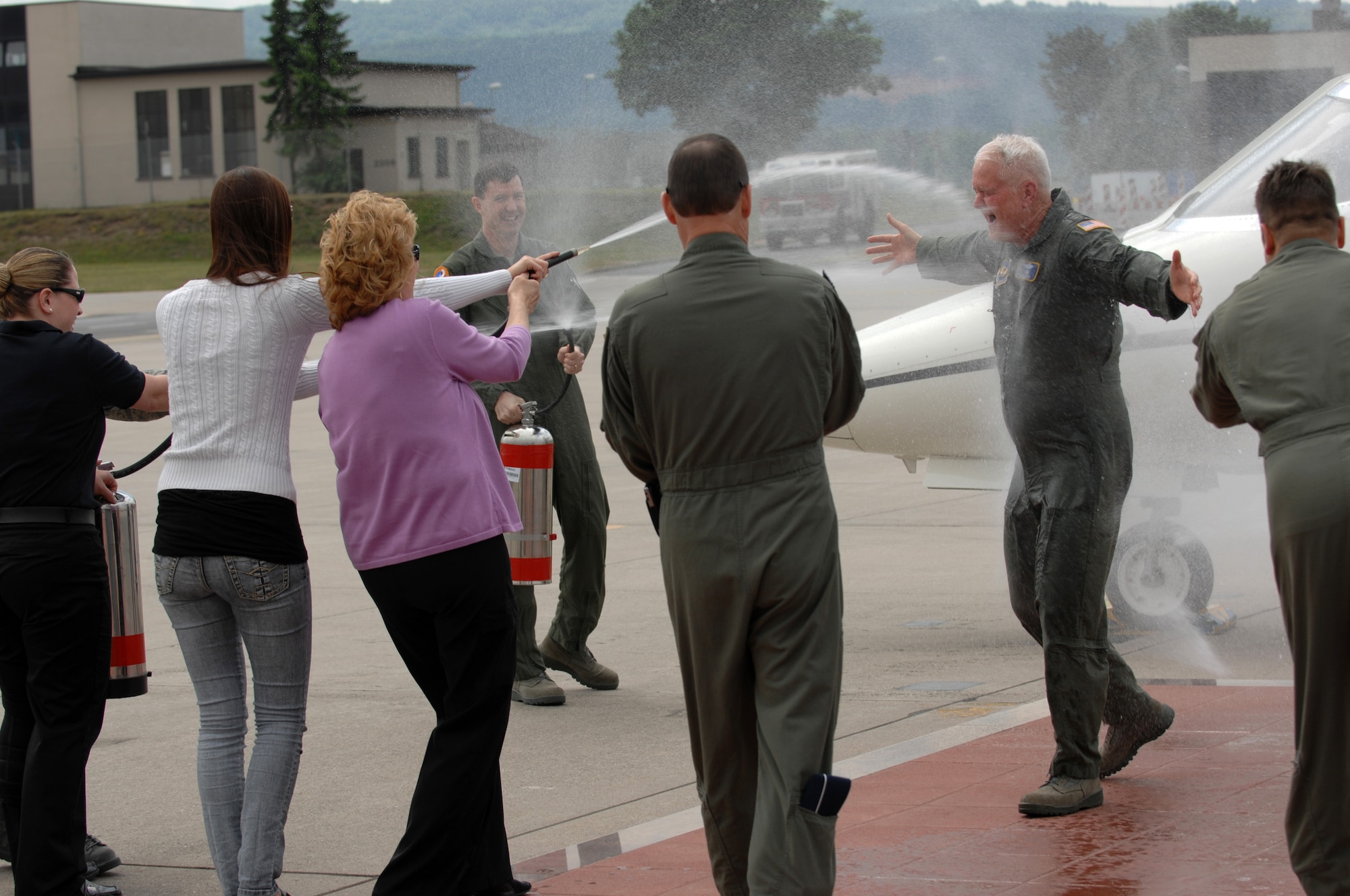 Lt. Gen. Robert D. "Rod" Bishop Jr., 3rd Air Force commander, gets sprayed down by family and friends (left to right: Tech. Sgt. Beverly Klaver, enlisted aide; daughter, Katie; wife, Mary; Brig. Gen. William Uhle, 3rd AF deputy vice commander; Brig. Gen. Richard Johnston, USAFE A-5/8/9 director; and Lt. Col. Dave Gunderson, 3rd AF executive officer) after his final flight, May 23. For his final flight Lt. Gen. Bishop flew a C-21. Courtesy photo