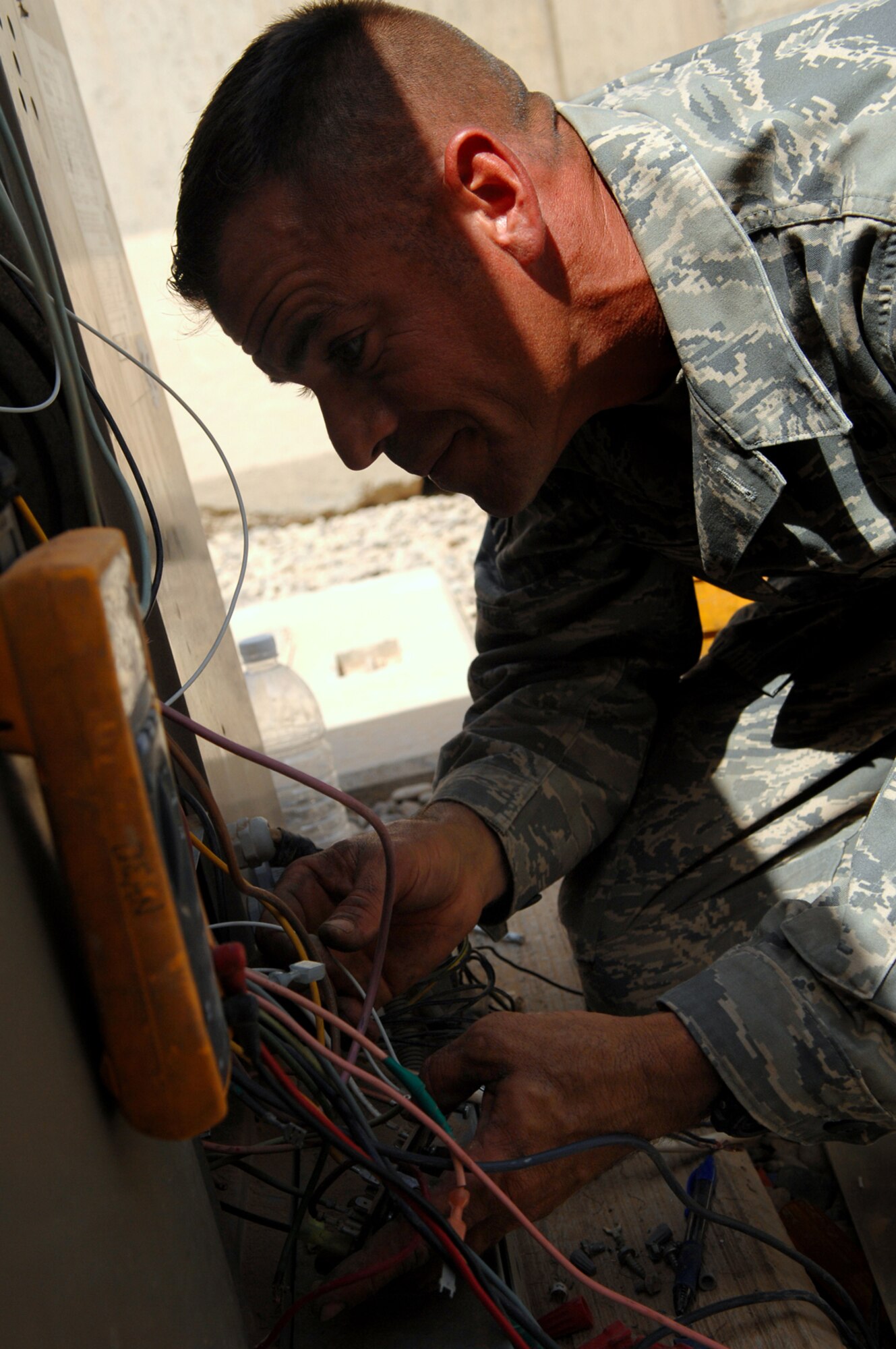 BALAD AIR BASE, Iraq -- Master Sgt. Jason Dean, 332nd Expeditionary Civil Engineer Squadron heating, ventilation and air conditioning special project manager, checks the electrical current passing through a packaged air conditioning system with a multimeter, an electronic measuring instrument, here, May 26. Refurbishing air conditioning systems is a four-day process that consists of pulling out all primary and secondary control wiring and then installing new wiring. Sergeant Dean is deployed from F.E. Warren Air Force Base, Wyo. (U.S. Air Force photo/ Senior Airman Julianne Showalter)