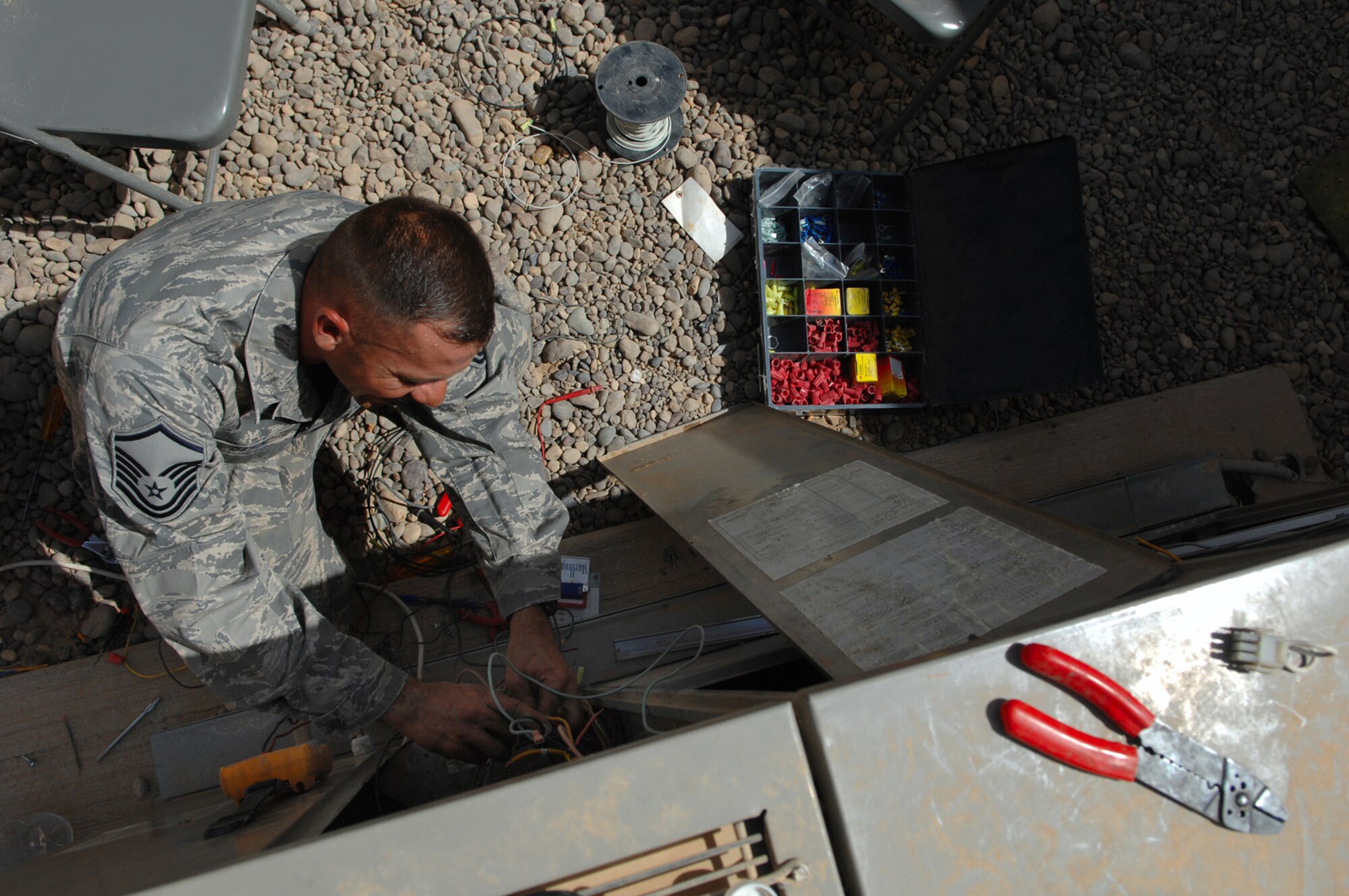 BALAD AIR BASE, Iraq -- Master Sgt. Jason Dean, 332nd Expeditionary Civil Engineer Squadron heating, ventilation and air conditioning special project manager, disconnects old wiring from a packaged air conditioning system here, May 26. Refurbishing an air conditioning system is a four-day process and consists of pulling out all primary and secondary control wiring and then installing new wiring. Sergeant Dean is deployed from F.E. Warren Air Force Base, Wyo. (U.S. Air Force photo/ Senior Airman Julianne Showalter)