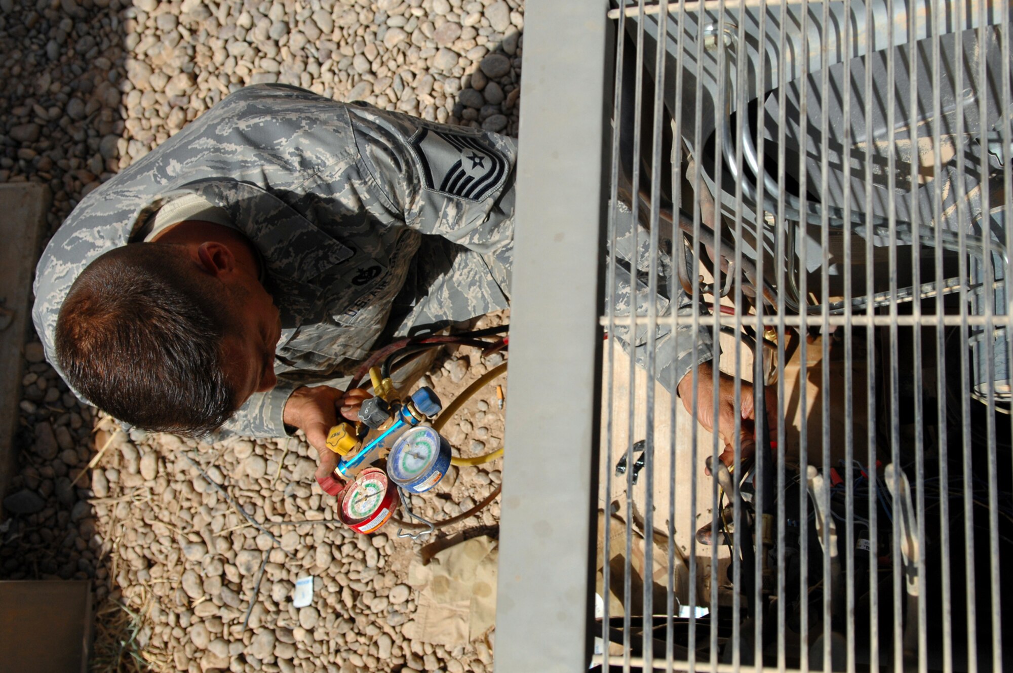 BALAD AIR BASE, Iraq -- Master Sgt. Jason Dean, 332nd Expeditionary Civil Engineer Squadron heating, ventilation and air conditioning special project manager, takes a reading from a refrigerant gauge here, May 26. The gauge gives internal diagnostic readings of coolant levels in air conditioning systems. Most daily temperatures at Balad AB this month have been either at or above 100 degrees Fahrenheit. Sergeant Dean is deployed from F.E. Warren Air Force Base, Wyo. (U.S. Air Force photo/ Senior Airman Julianne Showalter)