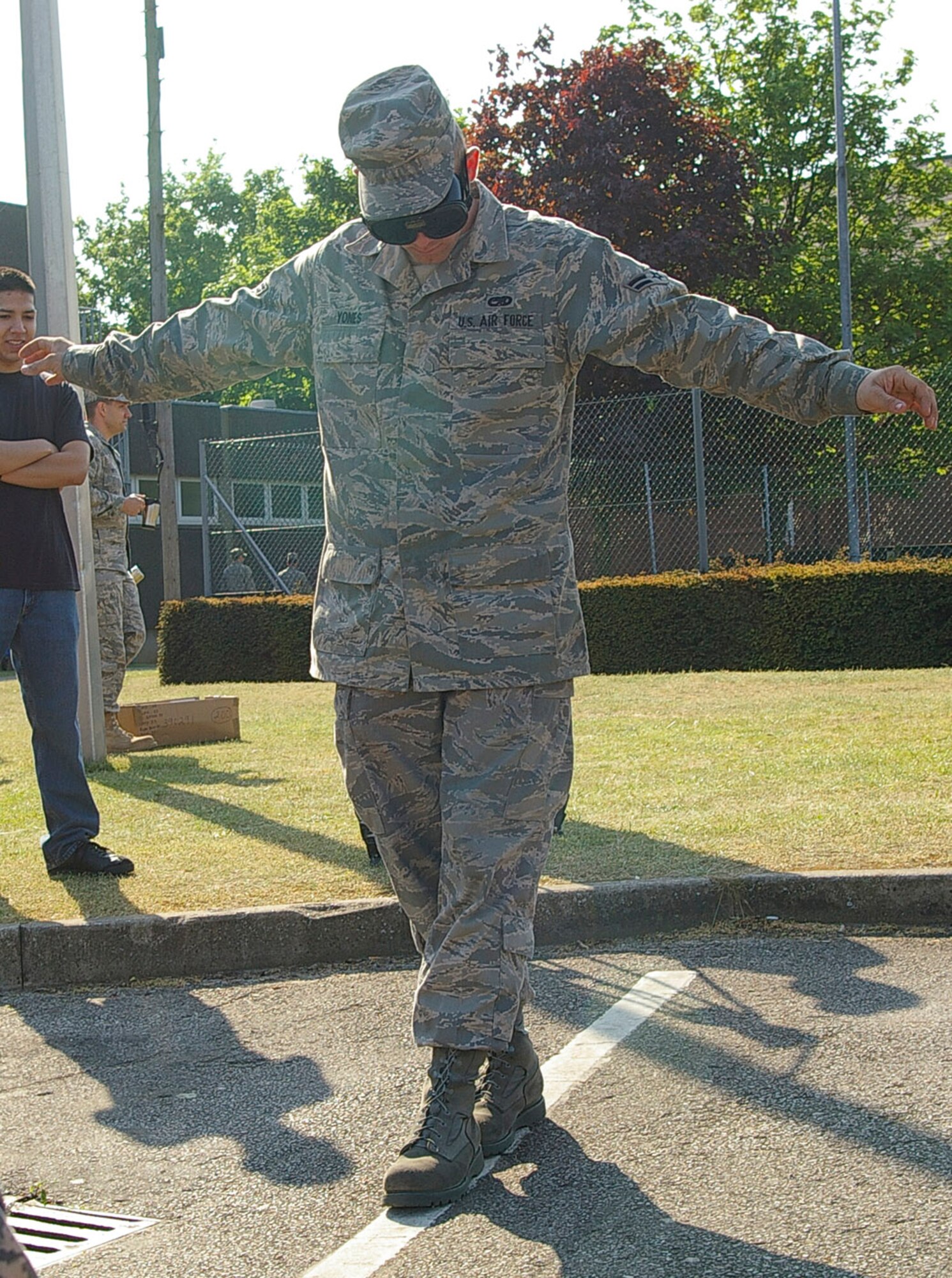Airman 1st Class Steven Yones, 100th Aircraft Maintenance Squadron, wears drunk goggles - simulating being three times over the legal blood-alcohol limit for driving - as he attempts to walk a straight line at one of the USAFE Safety Day demonstrations May 14. Volunteers from the AADD committee got people to wear the goggles to see the effects of being over the legal blood-alcohol limit. (U.S. Air Force photo by Karen Abeyasekere)