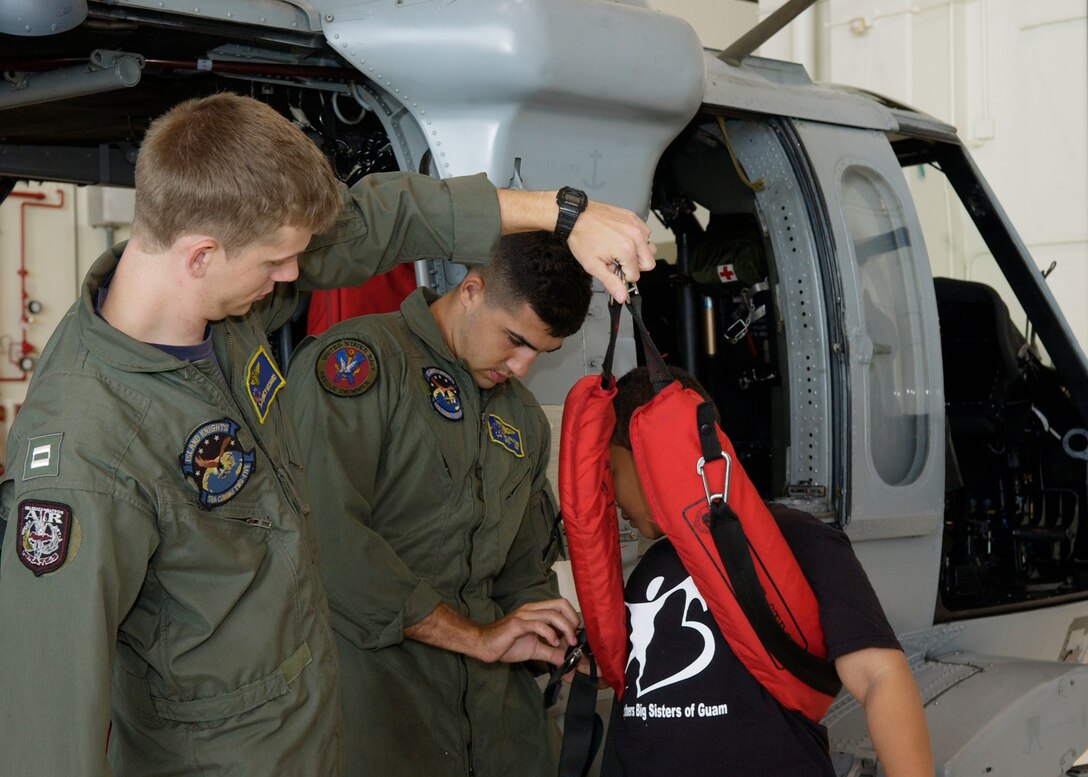 Lt. Quincy Hochard and Petty Officer Second Class Salcavatore Falcone of the Helicopter Sea Combat Squadron-25 present a rescue demo using Skyler Quchocho a "Little" from the Big Brothers Big Sisters program of Guam on May 24 here.  The Big Brothers Big Sister program of Guam toured HSC-25, the 734th Air Mobility Squadron, a U.S. Air Force C-17 Globemaster and C-5 Galaxy. (U.S. Air Force photo by Airman 1st Class Nichelle Griffiths)