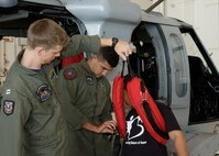 Lt. Quincy Hochard and Petty Officer Second Class Salcavatore Falcone of the Helicopter Sea Combat Squadron-25 present a rescue demo using Skyler Quchocho a "Little" from the Big Brothers Big Sisters program of Guam on May 24 here.  The Big Brothers Big Sister program of Guam toured HSC-25, the 734th Air Mobility Squadron, a U.S. Air Force C-17 Globemaster and C-5 Galaxy. (U.S. Air Force photo by Airman 1st Class Nichelle Griffiths)