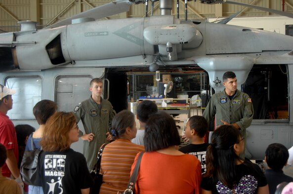 Lt. Quincy Hochard and Petty Officer Second Class Salcavatore Falcone of the Helicopter Sea Combat Squadron-25 present a rescue demo to children and parents from the Big Brothers Big Sisters program of Guam on May 24 here.  The Big Brothers Big Sister program of Guam toured HSC-25, the 734th Air Mobility Squadron, a U.S. Air Force C-17 Globemaster and C-5 Galaxy. (U.S. Air Force photo by Airman 1st Class Courtney Witt)     