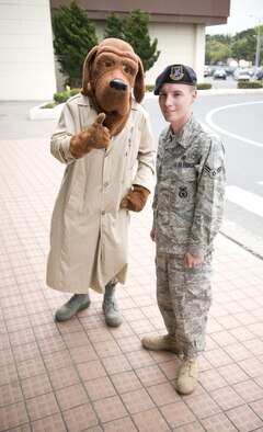 MISAWA AIR BASE, Japan -- Airman 1st Class Gary Clark, 35th Security Forces Squadron, escorts Scruff McGruff, the iconic crimefighting dog, outside the Misawa Base Exchange on May 13, 2008. McGruff was there to meet children and encourage them to "take a bite out of crime." (U.S. Air Force photo by Senior Airman Samuel Morse)