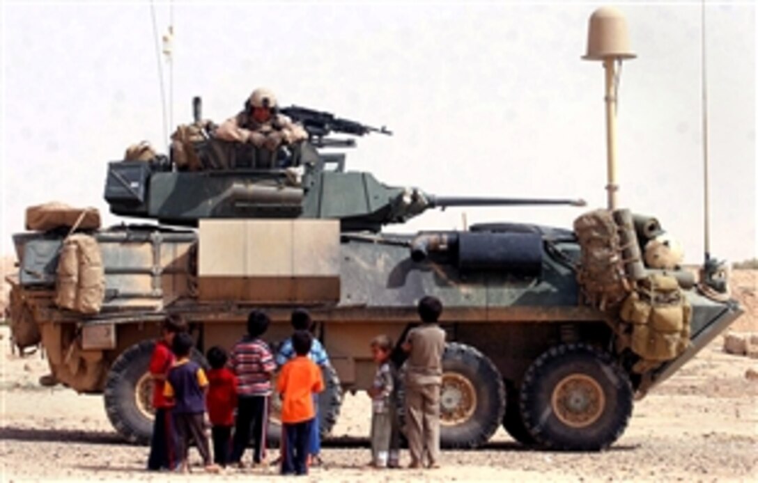 A U.S. Marine hands out candy to the children of a local village in the Salah Ad Din province, Iraq, May 18, 2008. The Marines are assigned to 2nd Light Armor Reconnaissance, Task Force Mech, Ground Combat Element, 1st Platoon, Alpha Company, Multinational Force West.