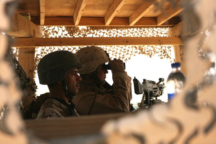 Lance Cpl. Ronald Wood Jr. (back), 22, a motor transportation operator, with the Provisional Rifle Platoon, RCT-5, and Adnan Nimrawi (front), an Iraqi soldier, stand watch at Combat Outpost Timberwolf, Iraq, May 27. The Marines trained the Iraqi Army soldiers with 7th Iraqi Army Division, 22nd Army Brigade to take over the outpost and to be able to successfully continue operations in the area.