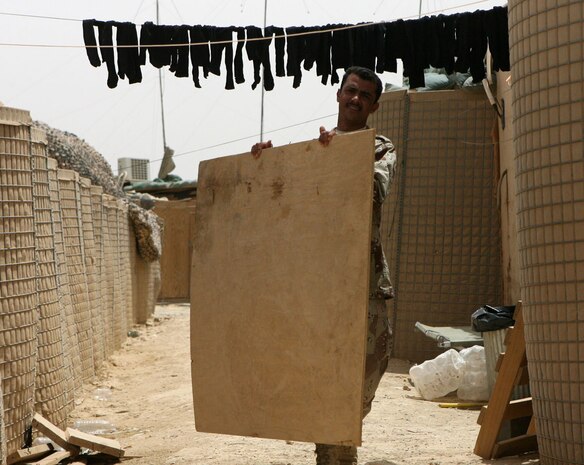 Wisam Al-Aamri, an Iraqi soldier, moves a piece of plywood at Combat Outpost Timberwolf, Iraq, May 27. The Marines with Headquarters Company, Regimental Combat Team 5 at COP Timberwolf previously relieved Marines with 3rd Battalion, 4th Marine Regiment, RCT-5 so they could focus on mission oriented operations. The trend has continued with transitioning the 7th Iraqi Army Division, 22nd Army Brigade into control of the outpost and surrounding area. The Marines trained the soldiers on patrolling procedures, guard duty and security measures.