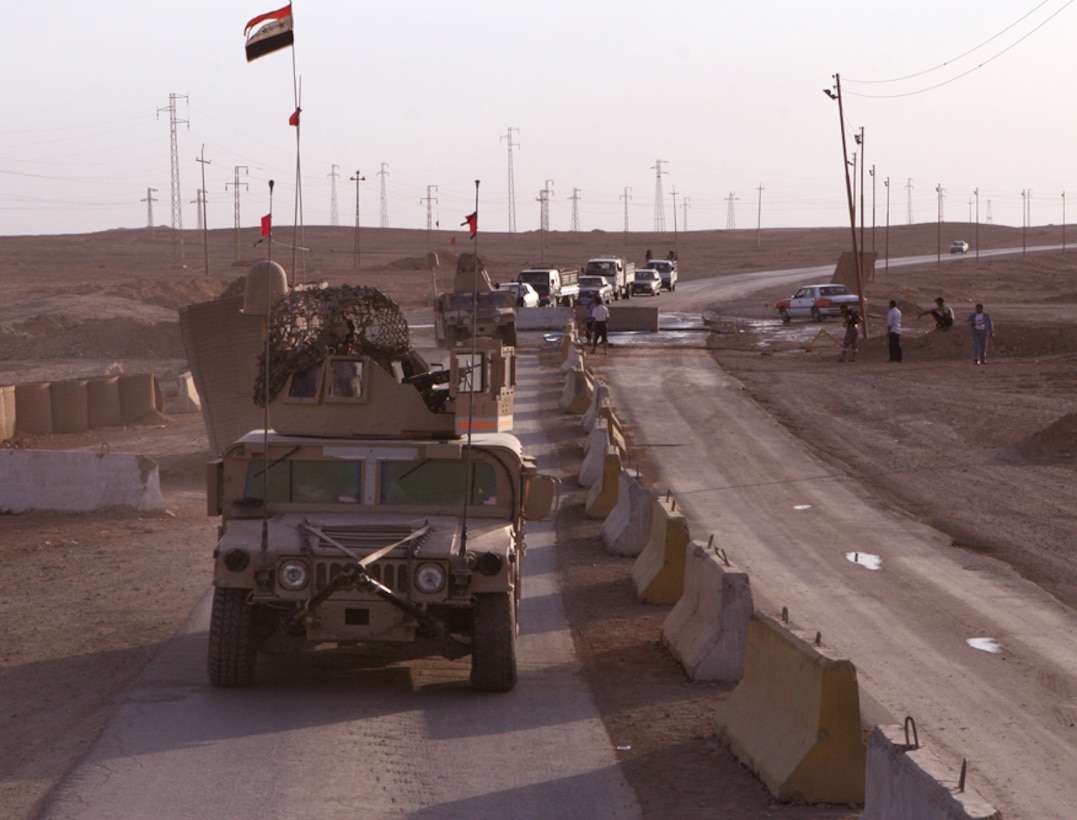 Marines with 1st Platoon, Golf Company, Task Force 2nd Battalion, 2nd Marine Regiment, Regimental Combat Team 5, pass through an Iraqi police checkpoint at Camp Gannon, Iraq, May 26th. The Marines of Company G have established a very strong relationship with the IP in their area of operation during the first few weeks of their deployment.  The Marines at Camp Gannon work with IP to help make a more secure environment for the people of Iraq.