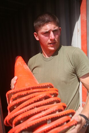 Lance Cpl. Joseph M. McDonough, 21, a warehouse clerk from Staten Island, N.Y., with Headquarters and Service Company, 2nd Light Armored Reconnaissance Battalion, Regimental Combat Team 5, carries florescent orange cones to issue them out at Camp Korean Village, Iraq, May 28. The warehouse clerks with 2nd LAR are on call 24-hours a day to ensure each Marine of the battalion and other residents aboard the camp have the supplies they need to complete the mission.