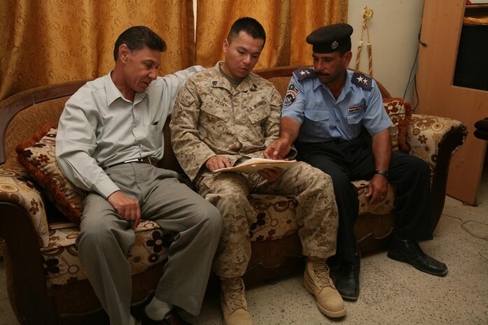 Staff Sgt. Moises E. Vilca, the intelligence chief for 3rd Battalion, 4th Marine Regiment, Regimental Combat Team 5, reviews information about the detainees being released with Iraqi Police Maj. Munir Hamid Mahdi (left) and IP Lt. Khamis Yaseen at Haditha, Iraq, May 27. Munir, the lead investigator for the Haditha IP District, said he was proud of how his officers performed during the occasion.   On this day, 23 detainees were released back to their homes and communities.