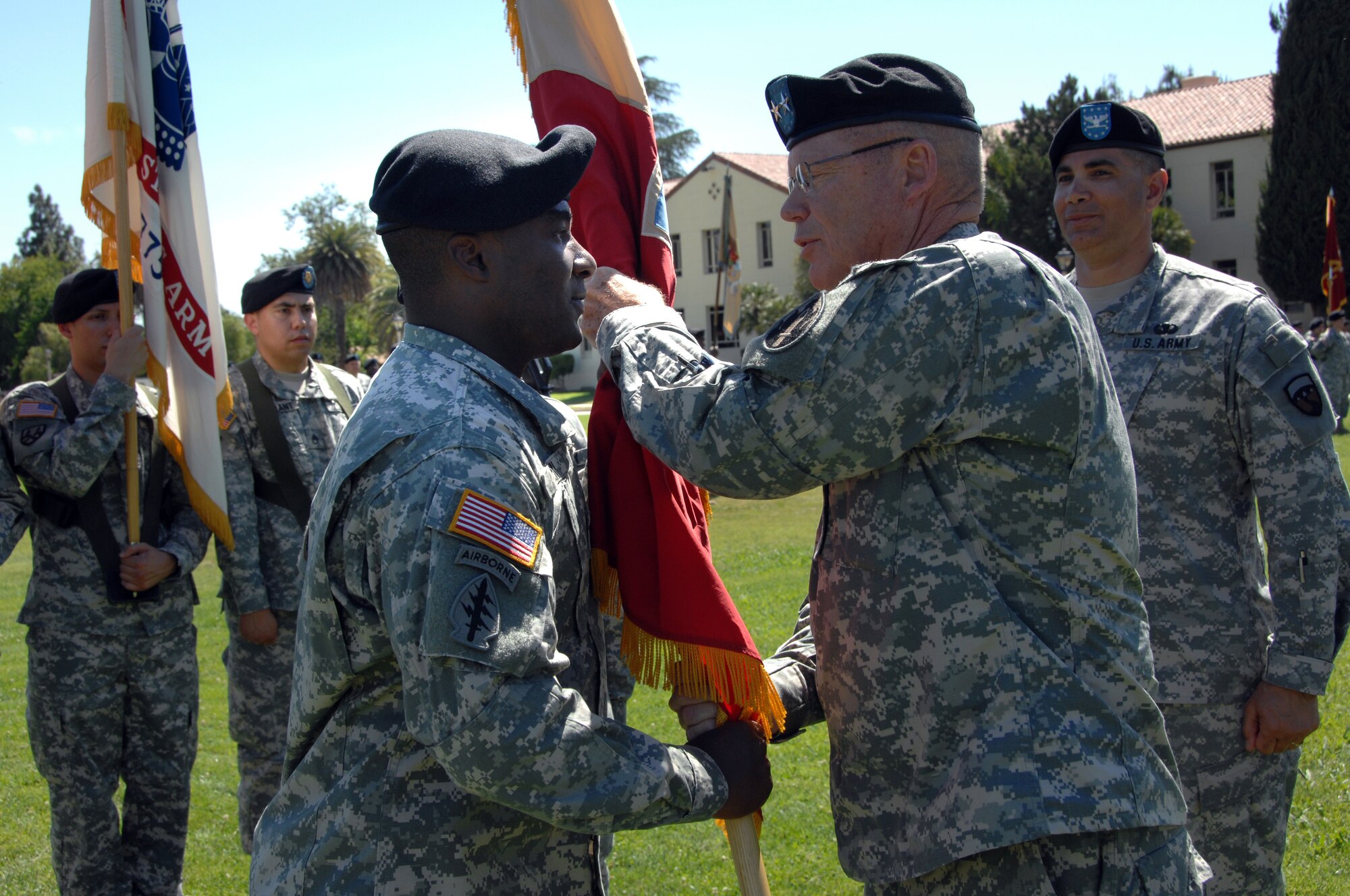 Major General Paul E. Mock, 63d Regional Readiness Command commander, hands the brigade flag to Lt. Col. Green at the base parade field. Brigade soldiers and community leaders attended the event. (U.S. Air Force photos by TSgt. Julie Avey, 163 RW)