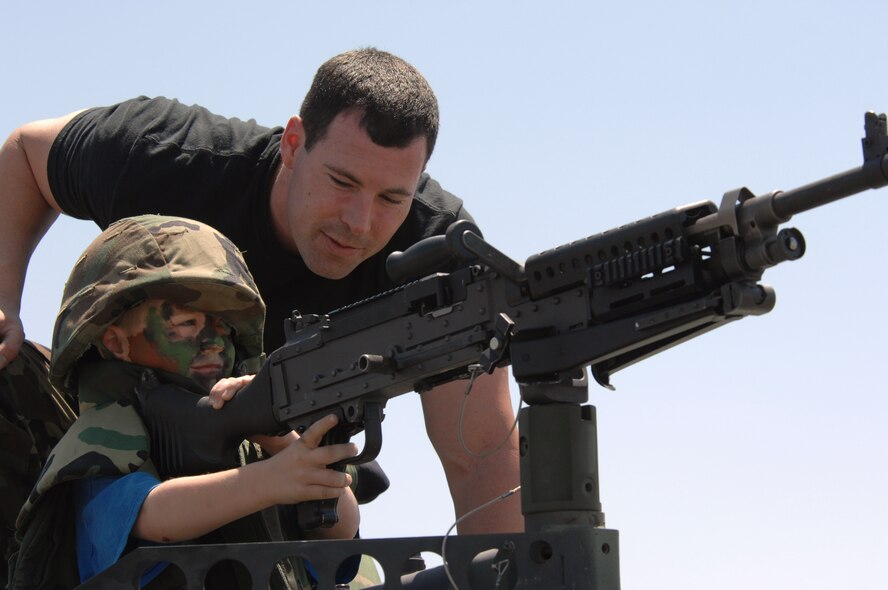 Senior Airman Thomas Capps, 452 SFS, shows a future security forces member a machine gun during the air show on Saturday. Dubbed “Thunder Over the Empire,” the biannual air show allows the civilian community the chance to interact with the military community. Almost 400,000 people viewed the show at the base, March Field Air Museum and from their parked cars along the streets surrounding the base. (U.S. Air Force photo by Technical Sgt. Joe Zuccaro)