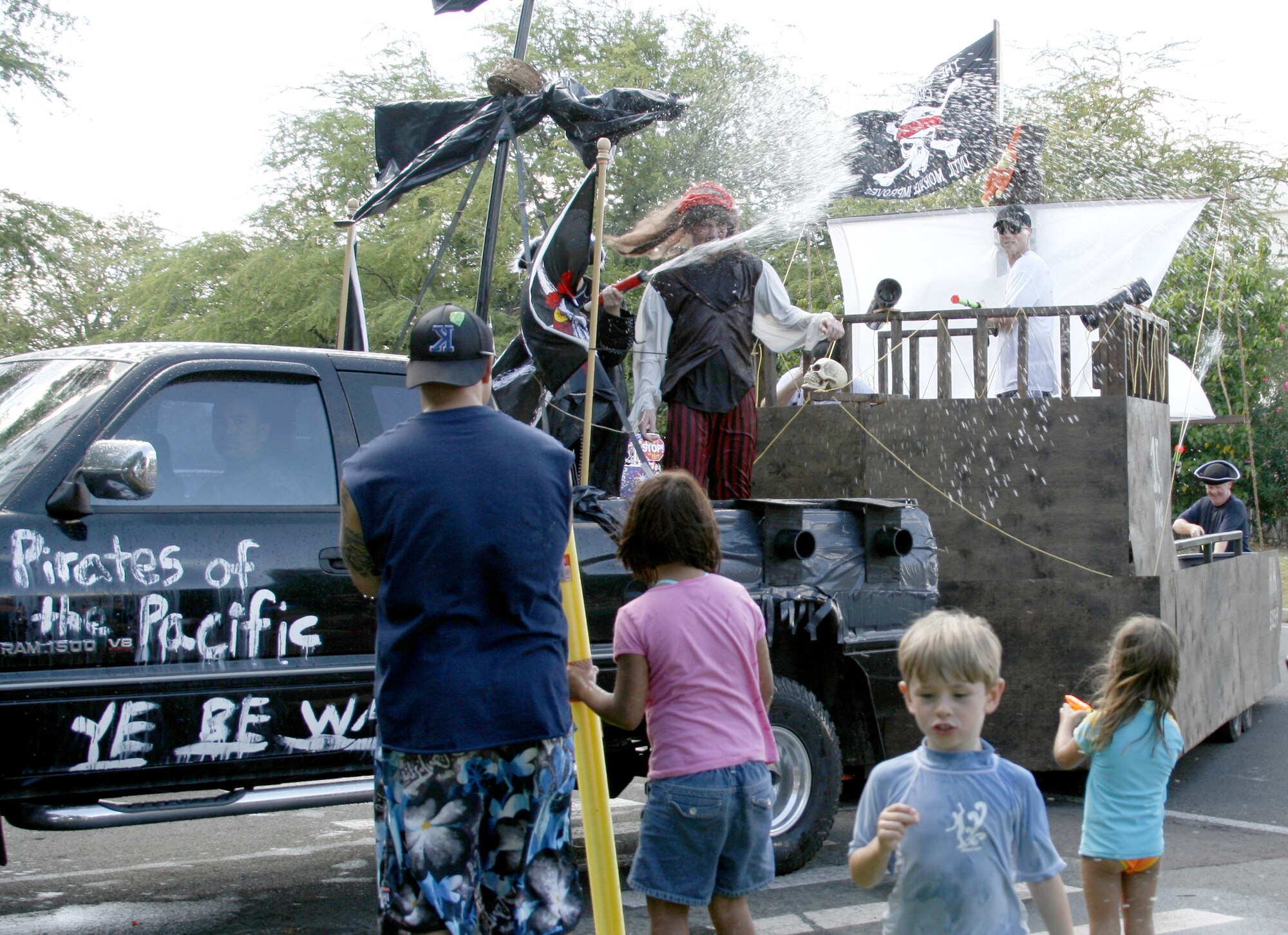 Team Hickam members soak parade floats as they pass by during the Beach Bum Parade, May 24. The Memorial Day weekend festivities at Hickam Harbor kicked off the summer season. Photo by Staff Sgt. Erin Smith