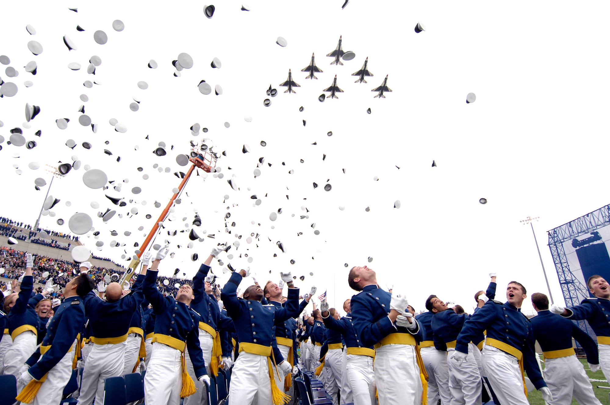 The Air Force Thunderbirds fly over the U.S. Air Force Academy's Falcon Stadium as 1012 newly graduated second lieutenants, members of the Class of 2008, toss their hats in the air at the conclusion of graduation ceremonies. President George W. Bush was the commencement speaker.  (U.S. Air Force photo/Mike Kaplan)