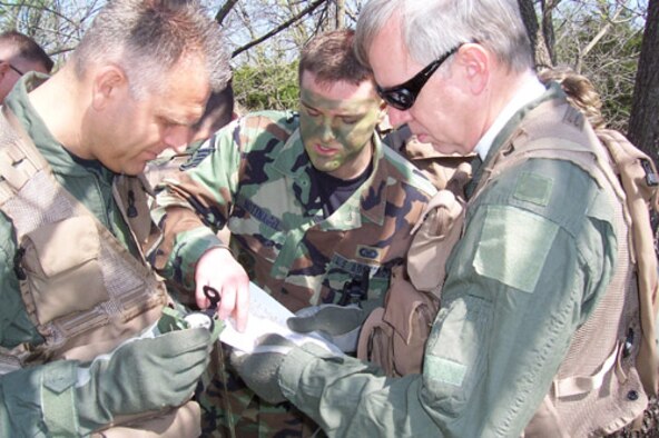 Major Mark VanCleave, left, and Lt. Col. Robert Everding, right, receive compass orienteering training from Staff Sgt Dustin Nottnagel during last month's survival trainng class.