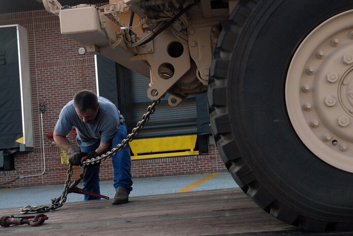 Brad Cochran secures a mine-resistant, ambush-protected vehicle to his trailer at the 437th Aerial Port Squadron yard May 28. The 437 APS traffic management office has been coordinating shipment of MRAPs to Marine Corps camps throughout the United States and overseas to be used for training purposes. Mr. Cochran is a driver with Landstar Ranger trucking company. (U.S. Air Force photo/Senior Airman Sam Hymas)