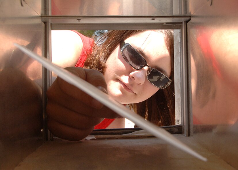 Ms. Stephanie Lietz delivers mail to a dorm resident's mailbox May 28, on Holloman Air Force Base, N.M.  Before the dorm residents receive their mail it is sorted by dorm and box numbers. (U.S. Air Force photo/Airman 1st Class John Strong)