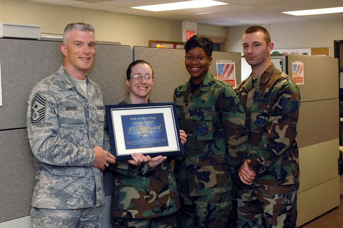 NELLIS AIR FORCE BASE, Nev.—From left to right, Chief Master Sgt. Robert Brooks, 99th Air Base Wing command chief, presents his monthly STAR award to Master Sgt. Donna Vipond, Airman 1st Class Ashley Dixson and Tech. Sgt. Shane Bailey, all with the 99th Medical Group during an informal ceremony here May 14, 2008. (U.S. Air Force photo/Senior Airman Jason Huddleston)