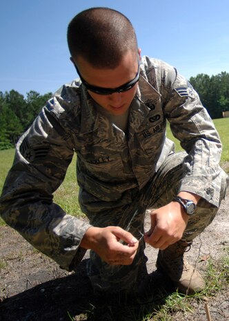 Senior Airman Johnathon Baxley joins two wires together to prevent any stray static electricity or electromagnetic radiation from setting off blasting caps before a planned detonation at a secure location on Charleston AFB May 22. Airman Baxley is an EOD equipment supervisor with the 437th Civil Engineer Squadron. (U.S. Air Force photo/Airman 1st Class Katie Gieratz)
