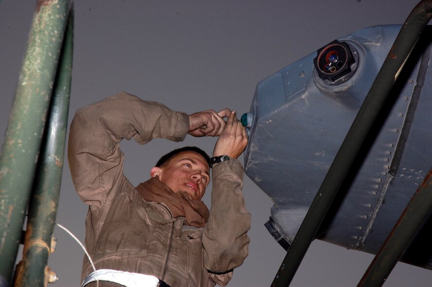 Airman 1st Class Buddy Bewick works on the beavertail navigation light of a C-130 Hercules at a Southwest Asia air base in preparation for an air-drop mission in southern Iraq. Airman Bewick is a 386th Expeditionary Aircraft Maintenance Squadron crew chief deployed from Dyess Air Force Base, Texas. (U.S. Air Force photo/Tech. Sgt. Michael O'Connor) 