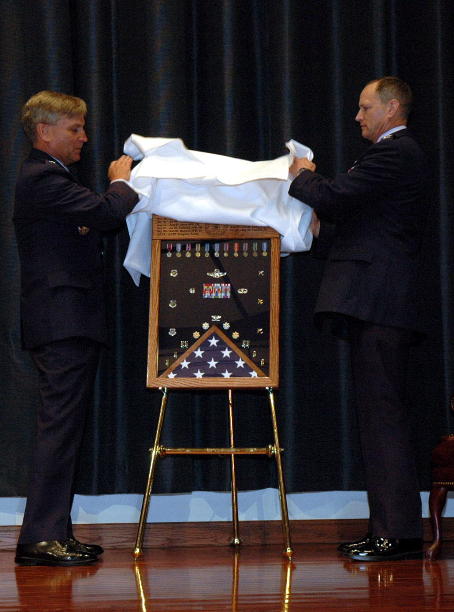 Maj. Gen. Kip Self, U.S. Air Force Expeditionary Center commander, and Col. Chuck Stiles, USAF EC vice commander, unveil the retirement shadow box for Colonel Stiles during his retirement ceremony May 22, 2008, in the USAF EC's Grace Peterson Hall on Fort Dix, N.J.  Colonel Stiles retired with 30 years of service to the Air Force.  (U.S. Air Force Photo/Tech. Sgt. Scott T. Sturkol)