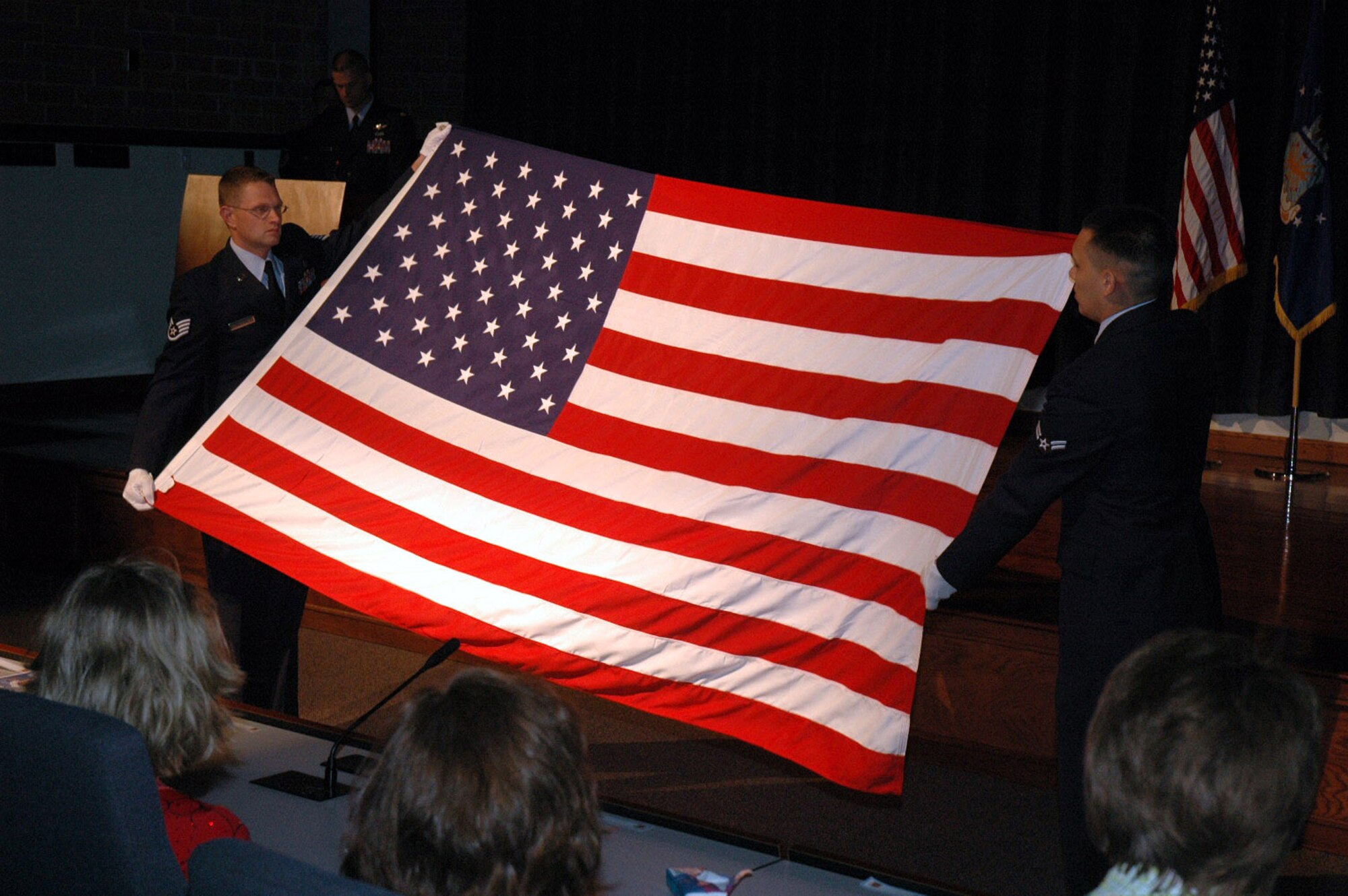 Staff Sgt. Jonathon McClure and Airman 1st Class Zachary Palafox, Mobility Operations School, perform a flag-folding ceremony during the retirment of Col. Chuck Stiles in the U.S. Air Force Expeditionary Center's Grace Peterson Hall May 22, 2008, on Fort Dix, N.J.  Colonel Stiles, the USAF EC vice commander, was later presented with the flag in honor of his 30 years of service.  (U.S. Air Force Photo/Tech. Sgt. Scott T. Sturkol)