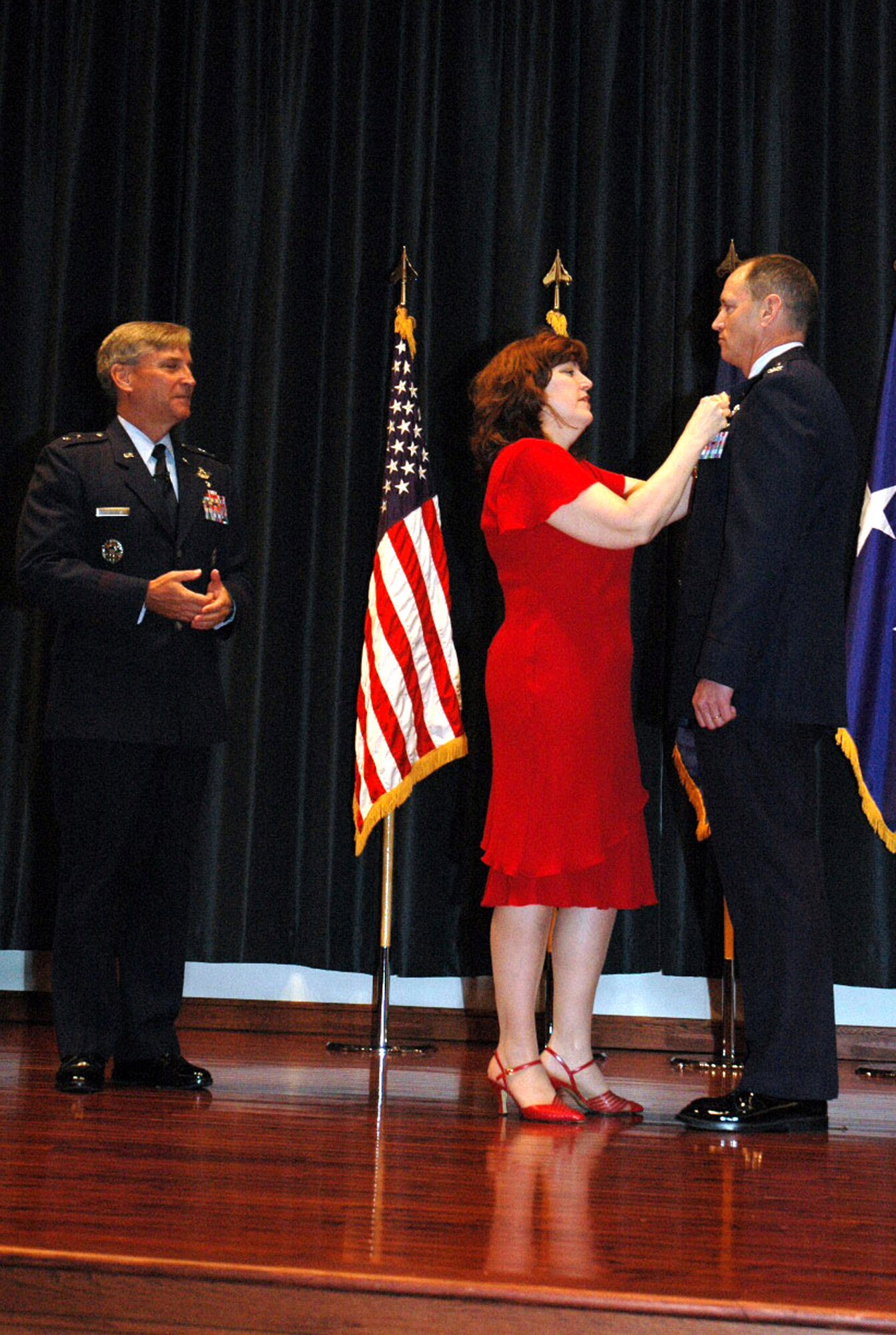 Maj. Gen. Kip Self, U.S. Air Force Expeditionary Center commander, watches as Mrs. Vickie Stiles places a retirement pin on her husband, Col. Chuck Stiles, USAF EC vice commander, during his retirement May 22, 2008, in the USAF EC's Grace Peterson Hall on Fort Dix, N.J.  General Self served as the presiding officer for the ceremony. Colonel Stiles retired with 30 years of service in the Air Force.  (U.S. Air Force Photo/Tech. Sgt. Scott T. Sturkol)