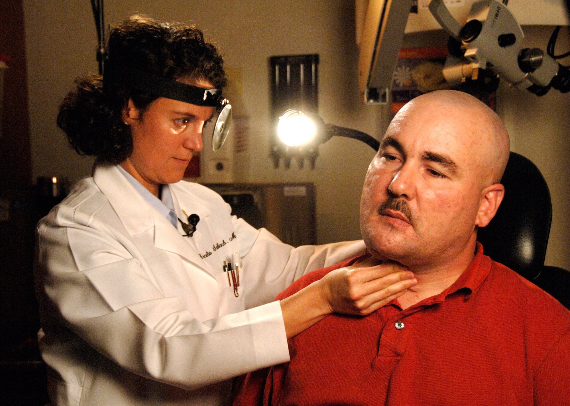 Maj. (Dr.) Cecelia Schalbach, chief of head and neck microvascular surgery at Wilford Hall Medical Center, Lackland Air Force Base, Texas, examines the progress of Army Staff Sgt. Terry Saffron's jaw rebuild. His jaw was injured by shrapnel from an improvised explosive device in May 2004 in Iraq.  Sergeant Saffron was referred to Wilford Hall for additional surgeries to treat his war wounds. (U.S. Air Force photo/Master Sgt. Kimberly A. Yearyean-Siers)