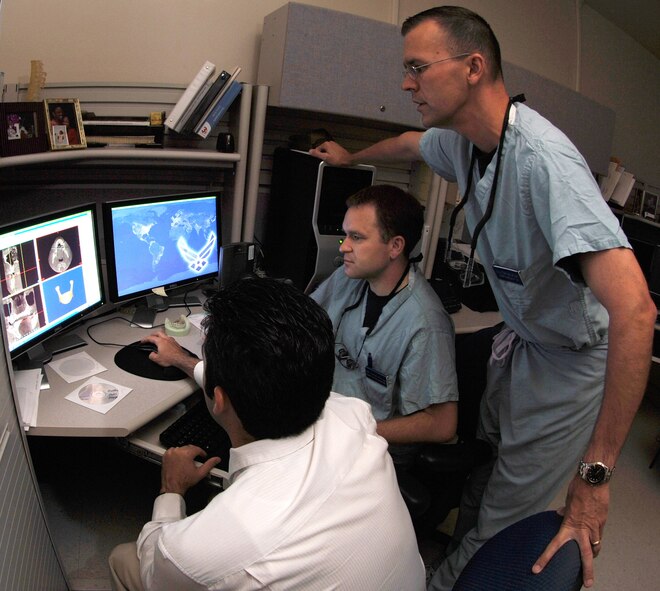 Alain Carballeyra (left), director of the 59th Medical Wing stereolithography lab at Wilford Hall Medical Center, Lackland Air Force Base, Texas, uses state-of-the-art graphic programs to make changes on a computer model to help Lt. Col. (Dr.) Steve Maller (center), director of resident education and training, and periodontic resident Capt. (Dr.) Josh Hethcox plan precise placement of implants for a patient.  Dental and oral surgeons from Wilford Hall and nearby Brooke Army Medical Center frequently enlist the aid of the stereolithography lab to develop treatment plans to minimize surgery and patient recovery time.  Colonel Maller and Captain Hethcox are with the 59th Dental Training Squadron. (U.S. Air Force photo/Master Sgt. Kimberly A. Yearyean-Siers)
