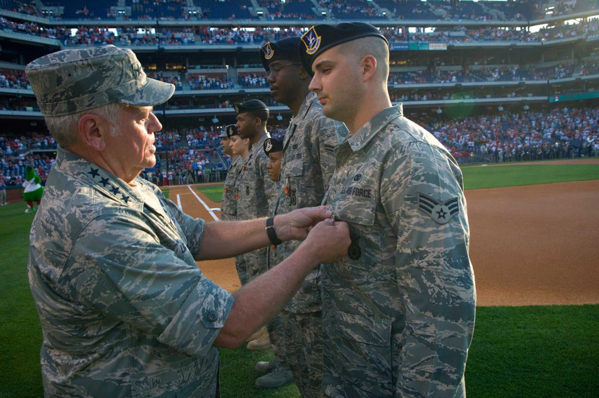 Gen. Arthur J. Lichte, commander of Air Mobility Command, awards Senior Airman Jonathan McMillan and six other Airmen the Combat Action Medal during pre-game activities at the Philadelphia Phillies - Colorado Rockies game May 26.  Activities at the game were held in conjunction with Air Force Week-Philadelphia.  The week is designed to broaden awareness of the U.S. Air Force's role in the war on terrorism and strengthen support for Airmen serving worldwide in defense of freedom.  Airman McMillan is a member of the 305th Security Forces Squadron, McGuire Air Force Base, N.J.  (U.S. Air Force photo/Staff Sgt. Bennie J. Davis III)