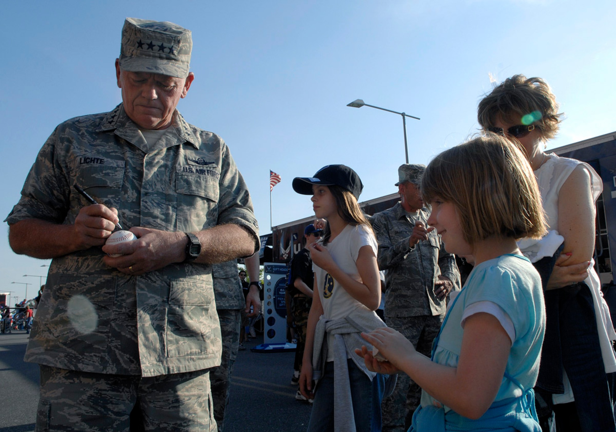 Gen. Arthur J. Lichte, commander of Air Mobility Command, signs a baseball for Katelynn Daniels during pre-game activities at the Philadelphia Phillies - Colorado Rockies game May 26.  Activities at the game were held in conjunction with Air Force Week-Philadelphia.  The week is designed to broaden awareness of the U.S. Air Force's role in the war on terrorism and strengthen support for Airmen serving worldwide in defense of freedom.  (U.S. Air Force photo/Staff Sgt. Bennie J. Davis III)