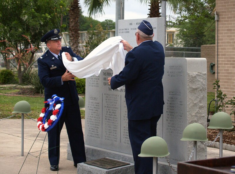 LAUGHLIN AIR FORCE BASE, Texas-- Col. John Doucette, 47th Flying Training Wing Commander, and Maj. Gen. Gerald Prather, USAF Ret. (back to camera), unveil a monument dedicated to four young men from Del Rio who made the ultimate sacrifice as members of the U.S. Armed Forces in Iraq and Afghanistan during the Memorial Day Ceremony in Del Rio May 26. The monument joins another honoring men from Del Rio who died while serving their country in World Wars One and Two, Korea and Vietnam. More than 100 people were on hand to witness the annual event.  (U.S. Air Force photo by Ron Scharven)


