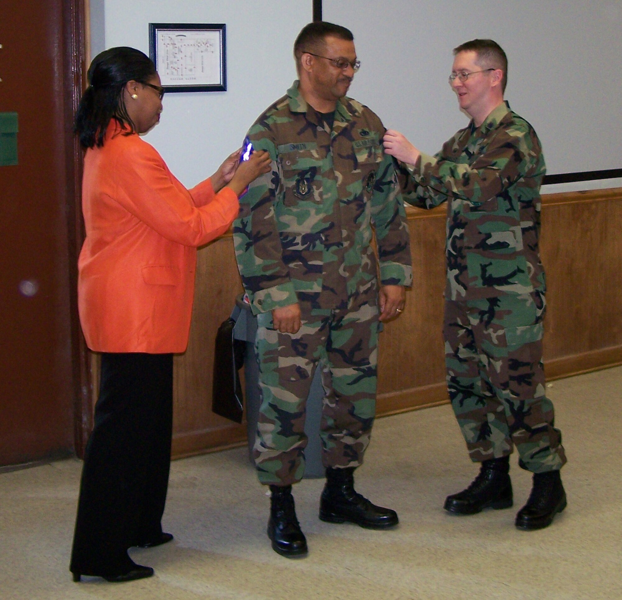 SEYMOUR JOHNSON AIR FORCE BASE, N.C. -- Newly promoted Chief Master Sgt. Kenny Smith (center) tacks on his new stripes during the May unit training assembly. Chief Smith is the superintendant of the 916th Maintenance Operations Flight.