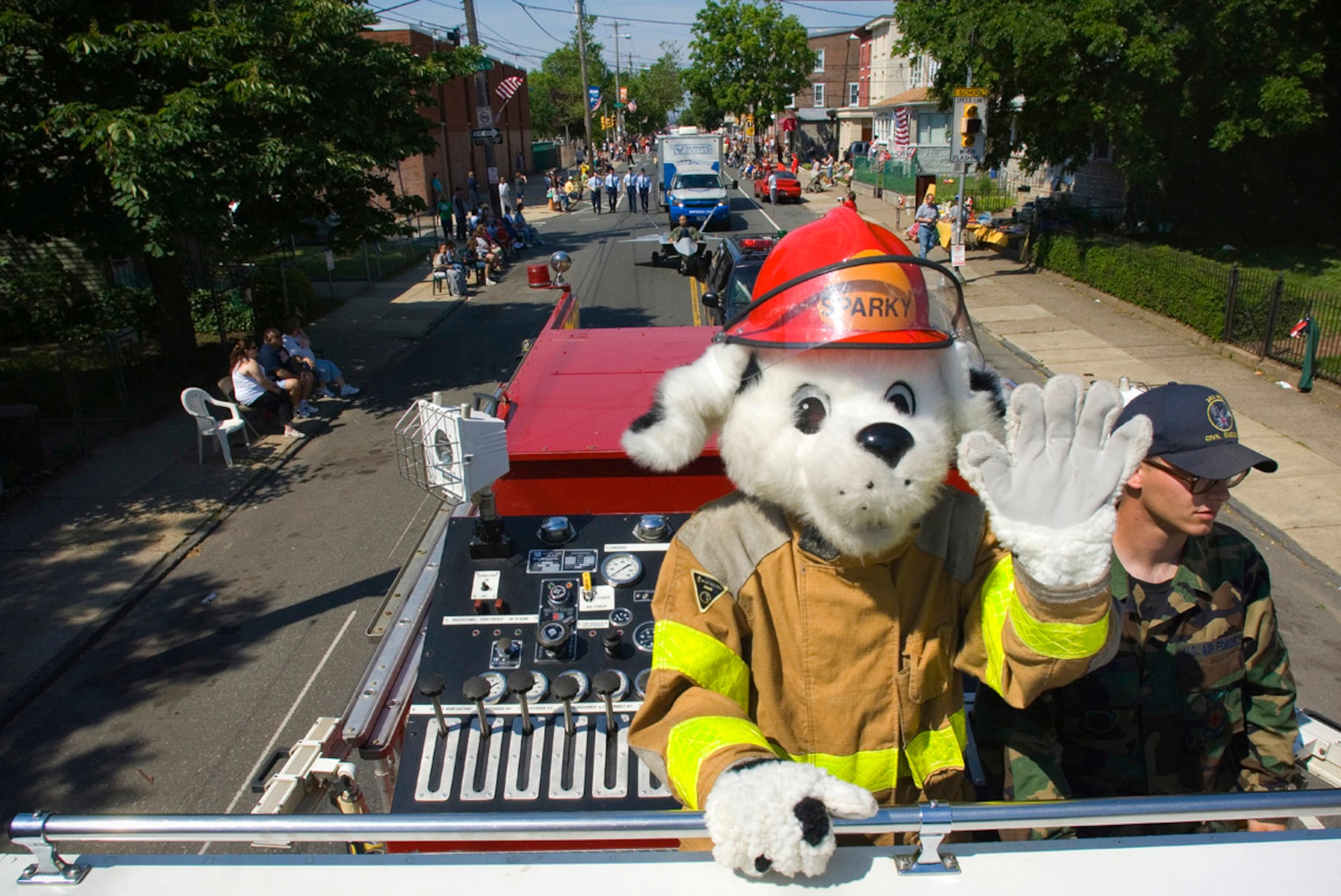 Sparky the Fire Dog catches a ride with the McGuire Air Force Base, N.J. fire department during the Bridesburg Memorial Day Parade May 26. Bridesburg is a borough in Philadelphia and hosted the kickoff celebrations for Air Force Week Philadelphia. Air Force Week Philadelphia is an event designed to build new relationships in the Philadelphia metropolitan area and strengthen public support for the Air Force mission and Airmen serving worldwide in the war on terrorism. (U.S. Air Force photo/Staff Sgt. Bennie J. Davis III)