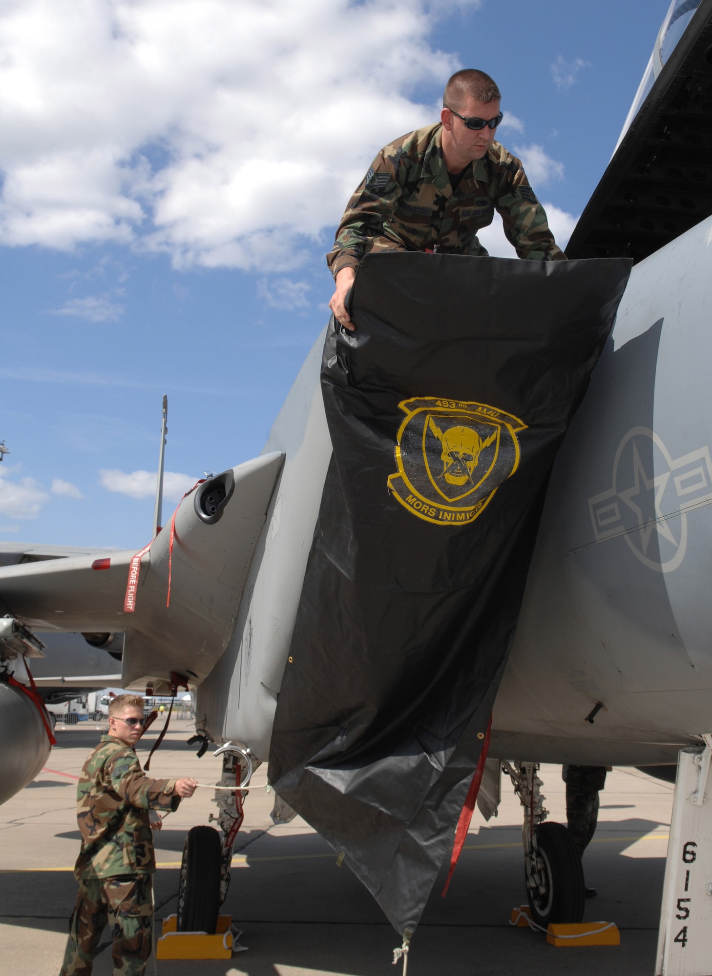 Staff Sgt. Russell Middleton (top) and Staff Sgt. Jeffrey Stout place the intake cover on an F-15 Eagle from the 48th Fighter Wing, Royal Air Force Lakenheath, United Kingdom here May 25 in preparation for the 2008 Berlin Airshow. U.S. participation in the Berlin Airshow enhances the U.S.-German military-to-military relationship and supports security cooperation strategic direction efforts. Sergeants Middleton and Stout are assigned to the 493rd Fighter Squadron at RAF Lakenheath, U.K. (U.S. Air Force photo/Tech. Sgt. Corey Clements)