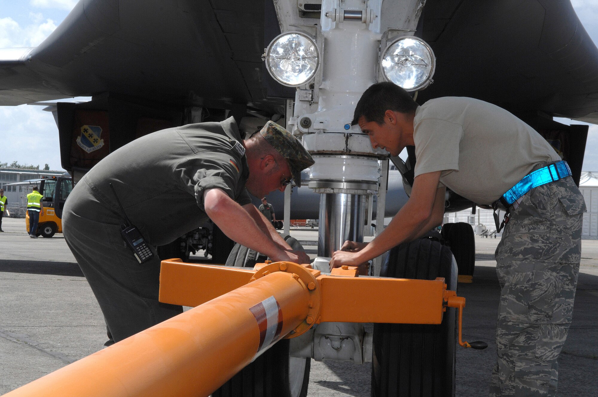 Senior Airman Marcus Smith (right) and German air force Master Sgt. Martin Ludwig prepare a B-1B Lancer bomber aircraft from the 7th Bomb Wing at Dyess Air Force Base, Texas, for towing during preparations for the 2008 Berlin Air Show here May 24. Airman Smith is an aircraft maintenance crew chief from the 7th Aircraft Maintenance Squadron at Dyess AFB. (U.S. Air Force photo/Tech. Sgt. Corey Clements) 