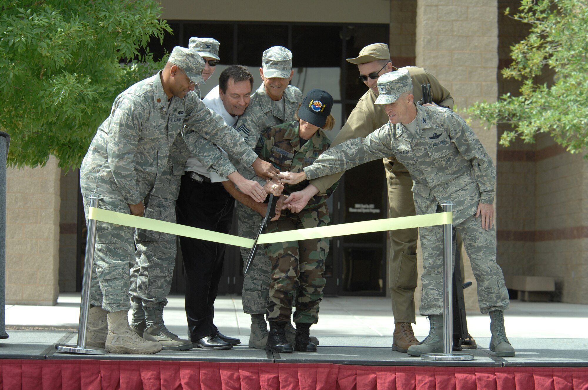 (From left to right) Maj. Jeremy Reid, 355th Services Squadron Commander, Col. Charles Hunter, Mission Support Group Commander, Charlie Dodd, Chief Master Sgt. James Parkhill, 355th Fighter Wing Command Chief, Senior Master Sgt. Angela Kamerer, 355th Medical Operations Squadron, Tech. Sgt. David Rogers, 55th Rescue Squadron, and Col. Kent Laughbaum, 355th Fighter Wing Commander, cut the ribbon at the rededication ceremony of the Arthur J. Benko Fitness Center, here, May 22. Technical Sgt. Arthur J. Benko was a World War II aerial gunner credited with shooting down 16 Japanese fighters, however, he gave his life attacking Japanese shipping near Hong Kong, China in 1943. (U.S. Air Force photo/Airman 1st Class Noah R. Johnson)
