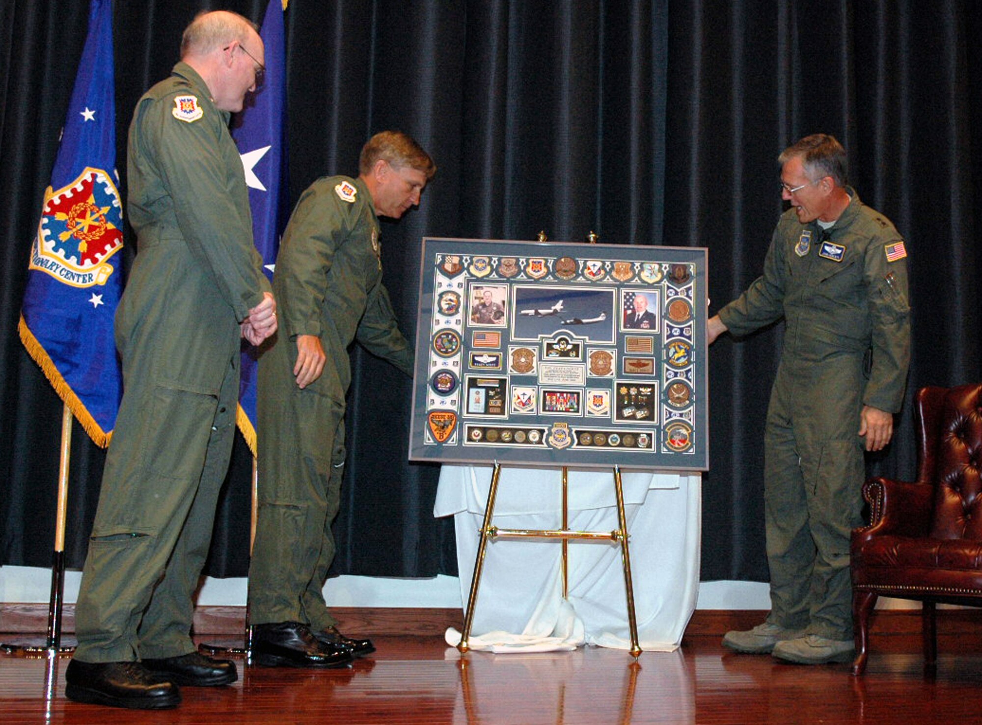 Maj. Gens. Kip Self and John Howlett unveil the retirement shadow box for Col. Tracy Scott during his retirement ceremony in the U.S. Air Force Expeditionary Center's Grace Peterson Hall May 16, 2008, on Fort Dix, N.J.  General Howlett, mobilization assistant to the commander of Air Mobility Command, Scott Air Force Base, Ill., was the presiding officer over the ceremony for Colonel Scott, the mobilization assistant to the commander of the USAF EC -- General Self. Colonel Scott retired after 30 years of service.  (U.S. Air Force Photo/Tech. Sgt. Scott T. Sturkol)