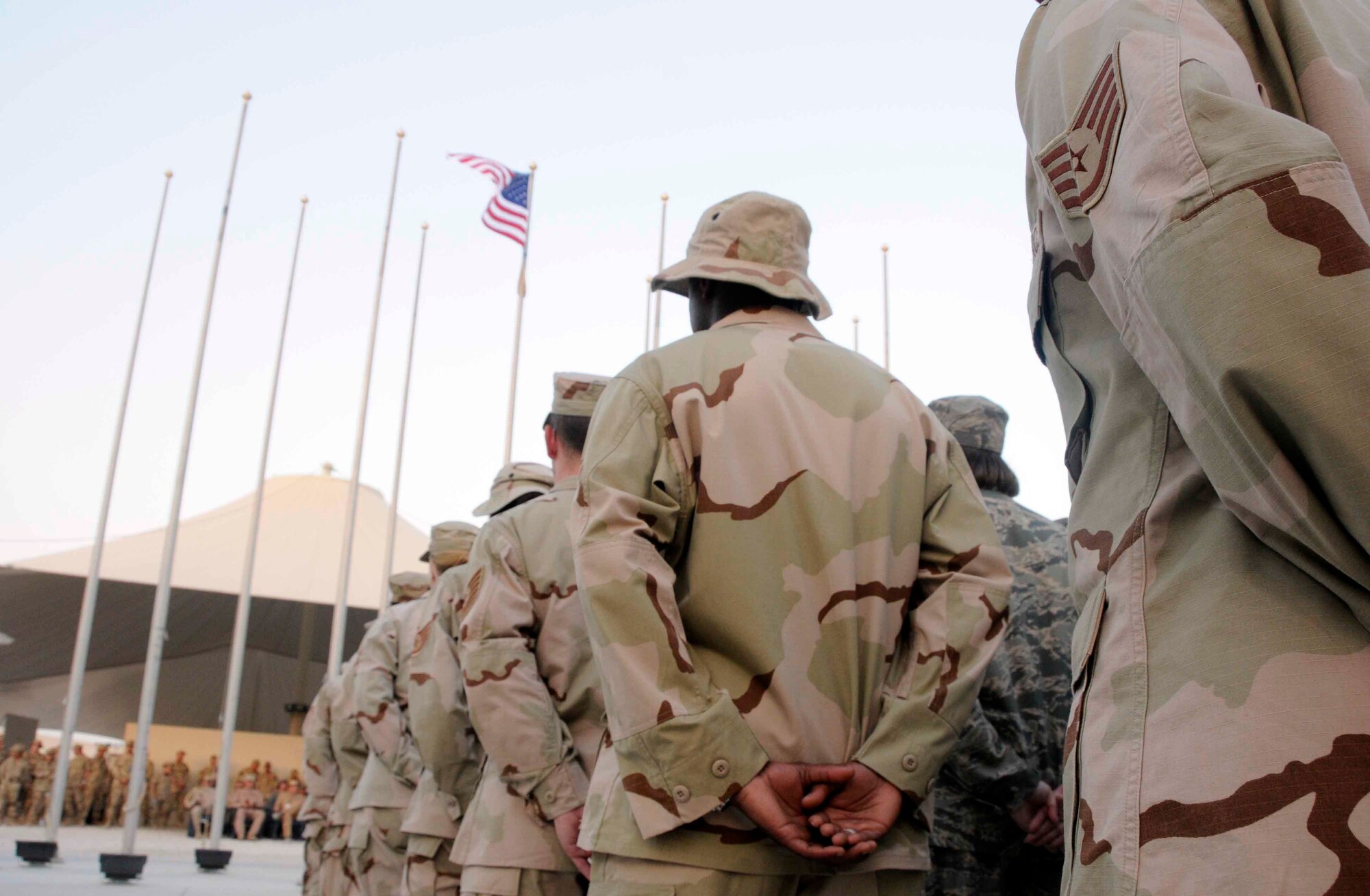 SOUTHWEST ASIA— A formation stands before the U.S. flag in honor of Memorial Day May 26. The 379th Air Expeditionary Wing celebrated Memorial Day with a retreat ceremony performed by the base honor guard. (U.S. Air Force photo/Senior Airman Domonique Simmons)