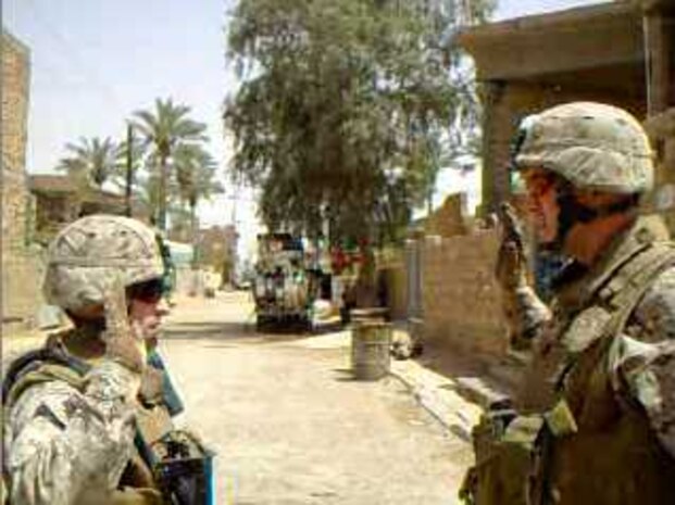 RAMADI, Iraq (May 28, 2008) – 1st Lt. David A. Moran (left) recites the oath of office given by Lt. Col. Brett A. Bourne (right) during his promotion ceremony at the site where his brother was hit by an improvised explosive device May 26. “I decided to get promoted at that intersection because that’s where my brother, Daniel, was hit,” David said. “He was on a night patrol with an Army IED sweeping team and while he was on that mission he was hit by a catastrophic IED. In that attack, his driver, his gunner, and his radio operator were killed. My brother and the vehicle commander survived.” (Courtesy photo)