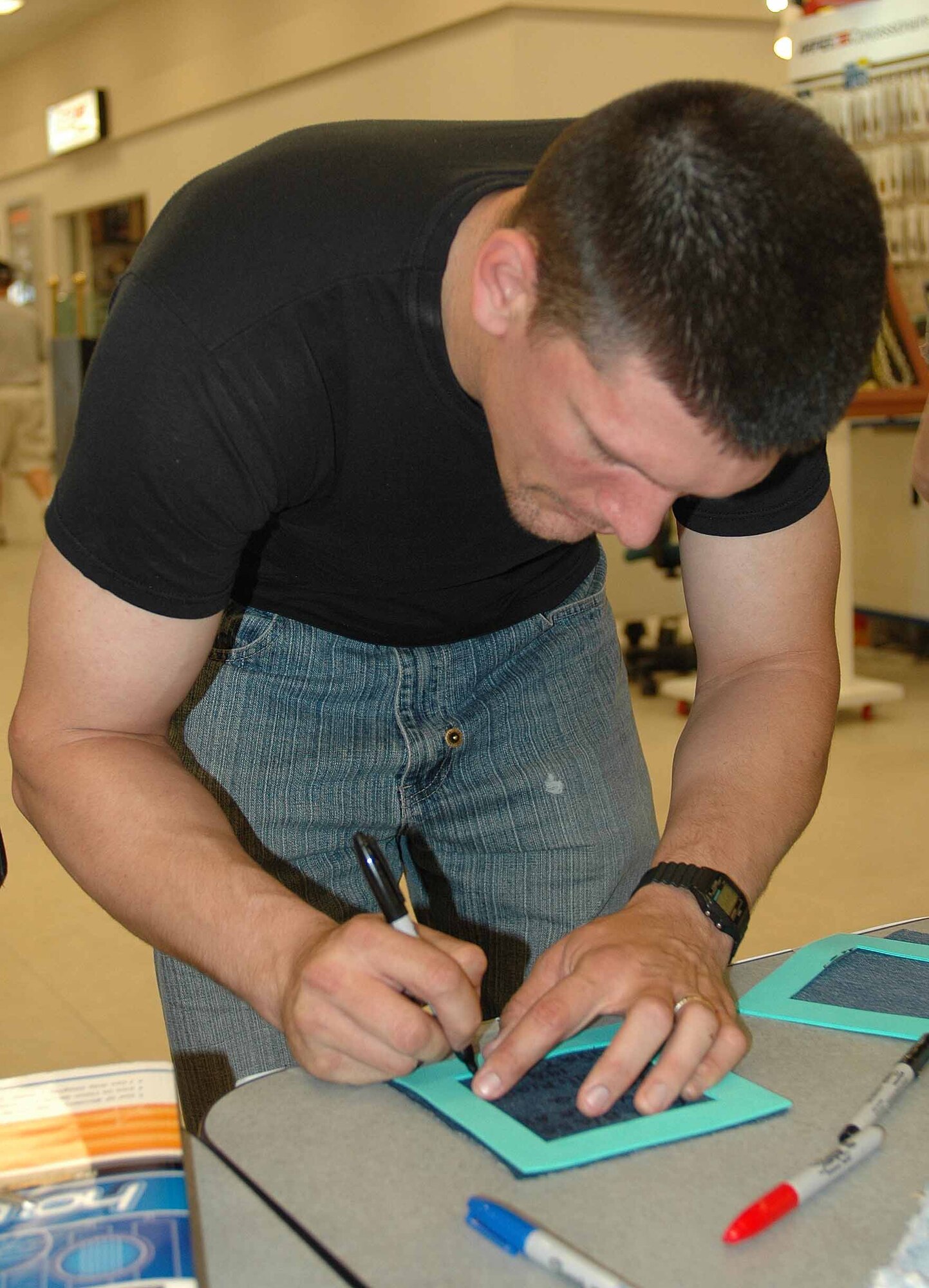 Staff Sgt. Jack Gilbert, 51st Security Forces Squadron, writes "from a fellow defender, thank you," on his square during the event. Team Osan members the opportunity to write heart-felt messages to wounded warriors returning from Iraq and Afghanistan during the Operation Quiet Comfort event May 24 and 25. (U.S. Air Force photo/Staff Sgt. Candy Knight)