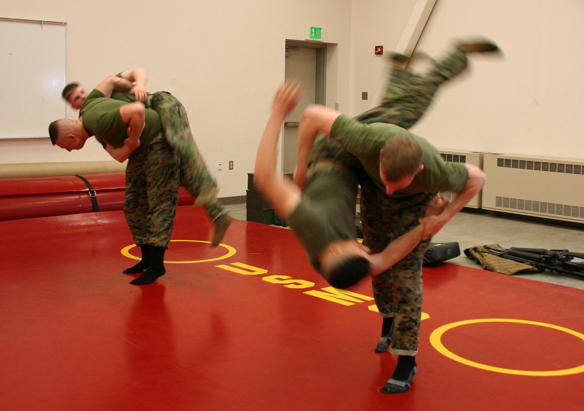 Marine Lance Cpl. Jason Christoffersen throws Lance Cpl. Edwin Anderson, while Cpl. Gary Himmighoefer throws Lance Cpl. Jeremy Langford during training in the Marine Corps Martial Arts Program at Elmendorf AFB. (U.S. Air Force photo/Ren?e Nelson)