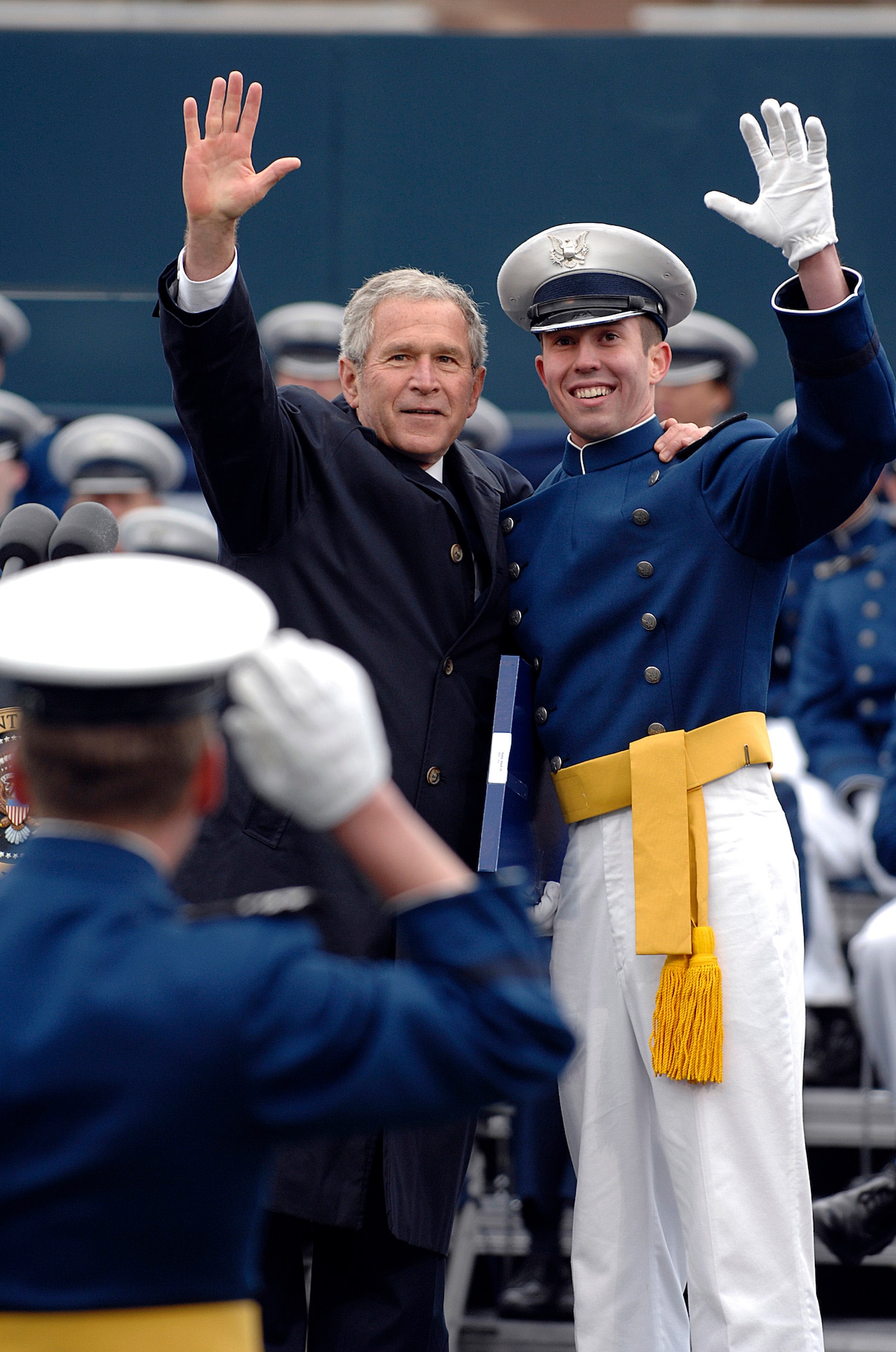 During the U.S. Air Force Academy graduation, President George W. Bush waves to the crowd with a cadet May 28 at Falcon Stadium. (U.S. Air Force photo/Dave Ahlschwede)