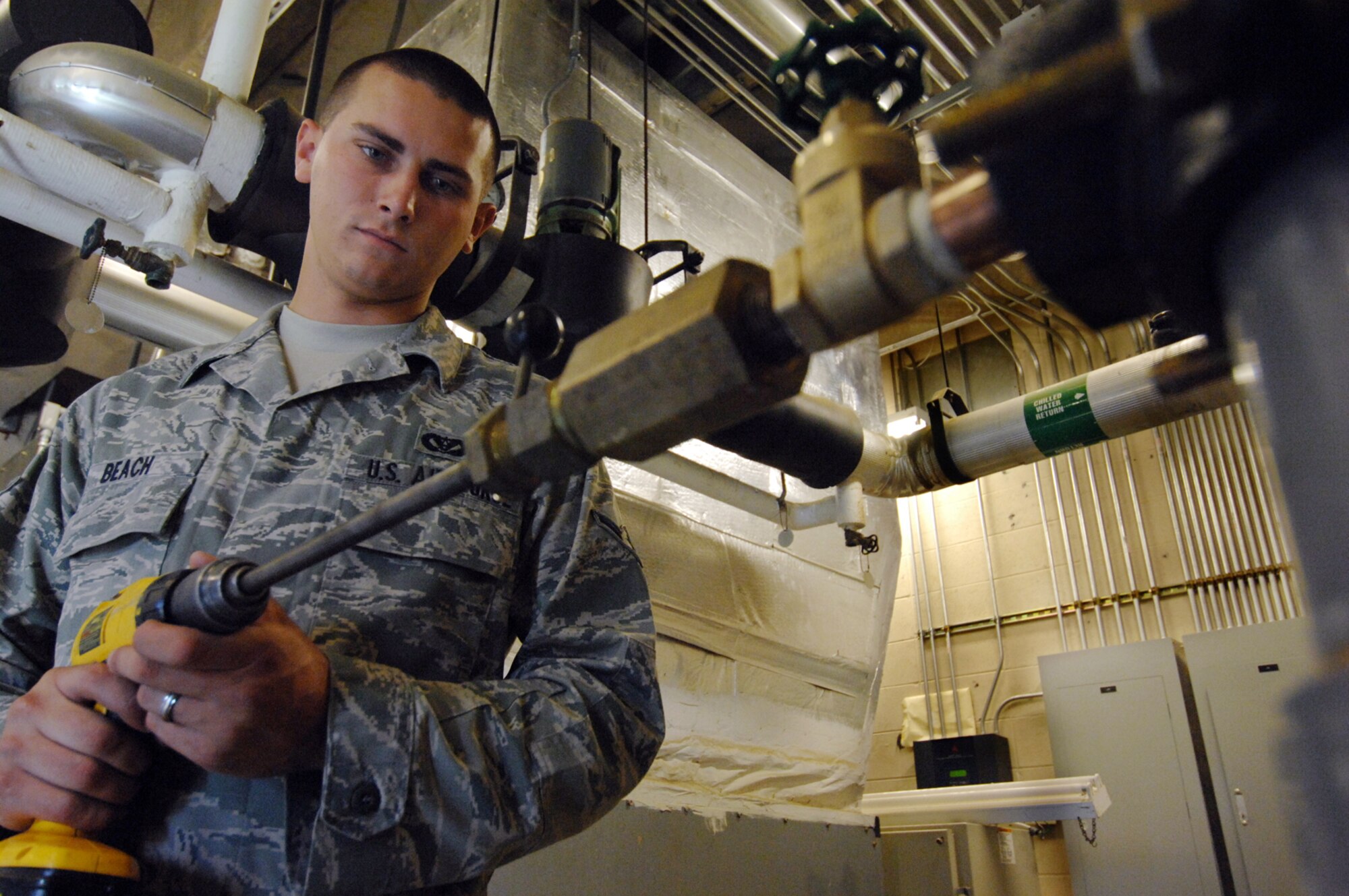 MOODY AIR FORCE BASE, Ga. - Airman Joshua Beach uses a cordless drill to run a tap through a pipe, cutting new threads for a water spigot installation here May 29. Airman Beach is a utilities systems specialist with the 23rd Civil Engineer Squadron. (U.S. Air Force photo by Staff Sgt. Joshua T. Jasper)