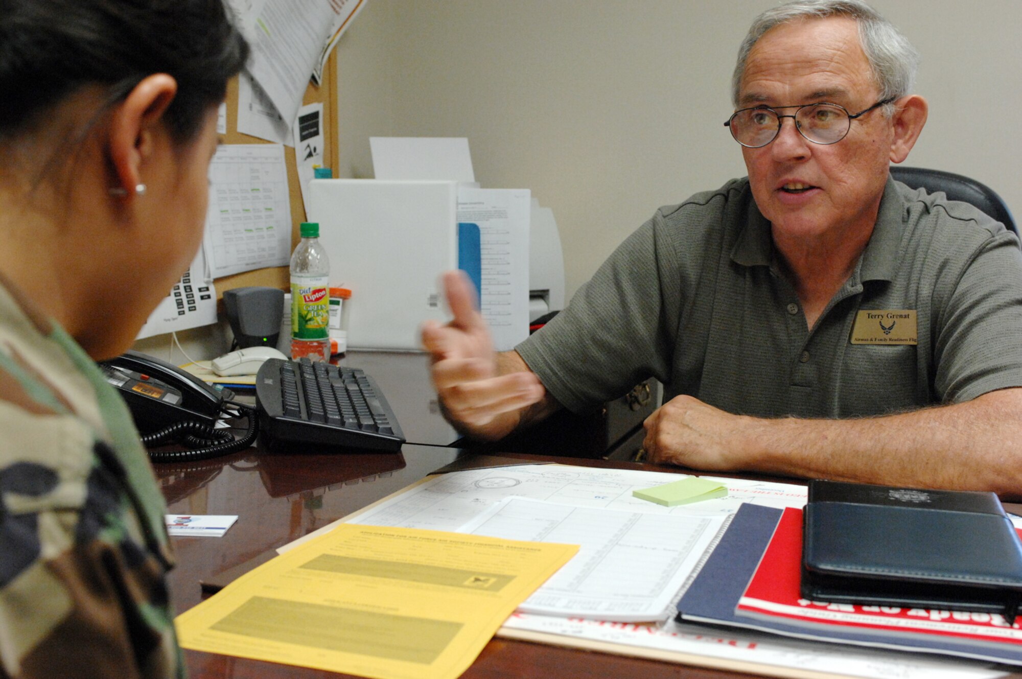MOODY AIR FORCE BASE, Ga. - Terry Grenat, Airman and Family Readiness Center community readiness consultant, guides an Airman through the process of applying for a financial assistance loan here May 28. Mr. Grenat is retiring soon after a combined military and civil career of 45 years. (U.S. Air Force photo by Staff Sgt. Joshua T. Jasper)