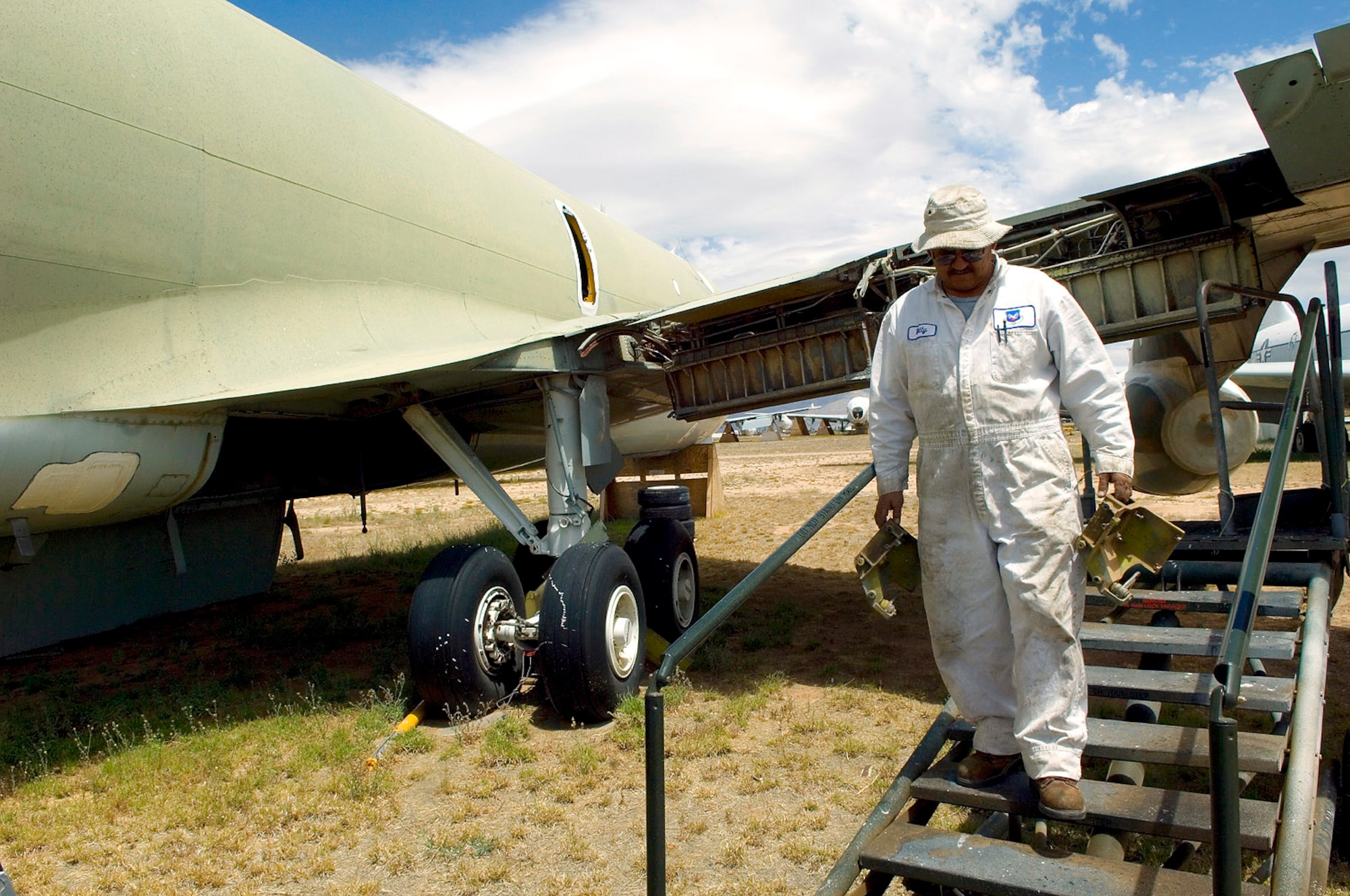 Aircraft mechanic Bill Amparano removes support brackets from the wings of a preserved KC-135E Stratotanker at the Aerospace Maintenance and Regeneration Group storage site at Davis-Monthan Air Force Base, Ariz.  The brackets will be shipped to Tinker Air Force Base, Okla., where they will be used to bring a broken KC-135R back to flying status. AMARG's mission has evolved beyond merely the storage and preservation of aircraft.  Today the center provides customer services including aircraft regeneration which means restoring aircraft to flying status, limited depot-level maintenance, parts reclamation, historic storage and disposal functions.  (U.S. Air Force photo/Bennie J. Davis III)
